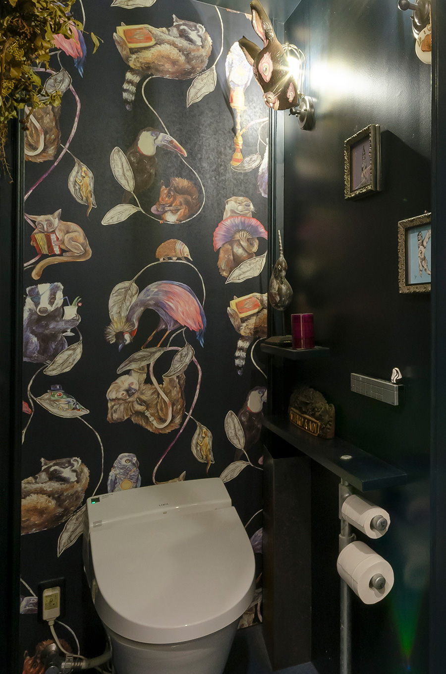 黒でシックに統一されたトイレ。動物たちが描かれた個性的な壁紙は奥様のこだわり。