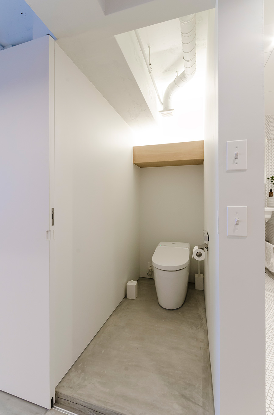 トイレもモルタル塗装でシンプルに統一。