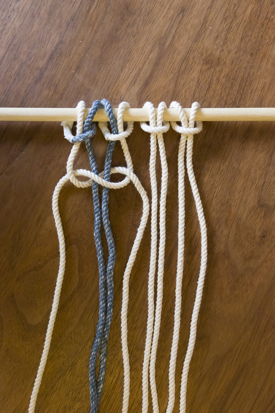 ②隣り合う４本のロープを編む。”右”端のロープを、真ん中の２本の “上”を通り左端のロープにくぐらせる。左端は真ん中をくぐらせて先端を通す。