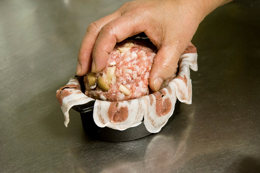 ④ひき肉と練り合わせたものをひとまとめにして、バラ肉を敷いたココットの中に入れる。
