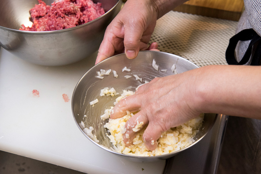 ①パン粉、卵、牛乳を練り合わせておいてから、タマネギのみじん切りを加えて混ぜる。