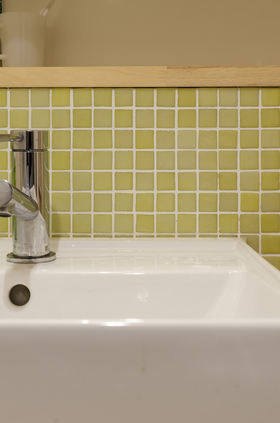 洗面台のタイルもグリーンで清潔感のある空間に。