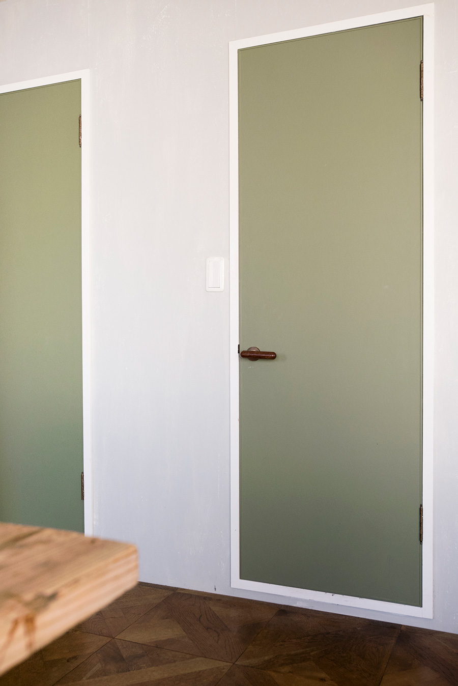 バスルームとトイレのまわりの壁はムラのあるグレーに。ドアはモスグリーンでペイント。