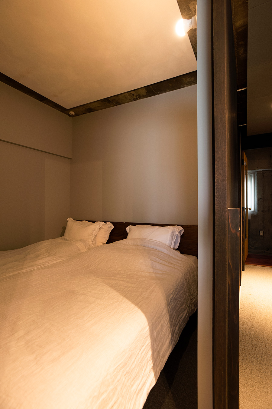 ベッドルームの壁はやや明るいグレーに。天井は白い板でコンクリートを目隠ししている。