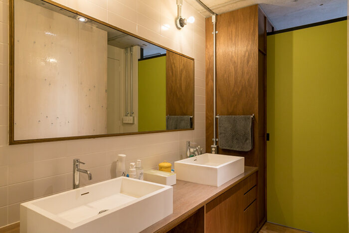 寝室と洗面所の間は引き戸で仕切ることもできる。大型の鏡とダブルシンクのホテルライクな洗面台。