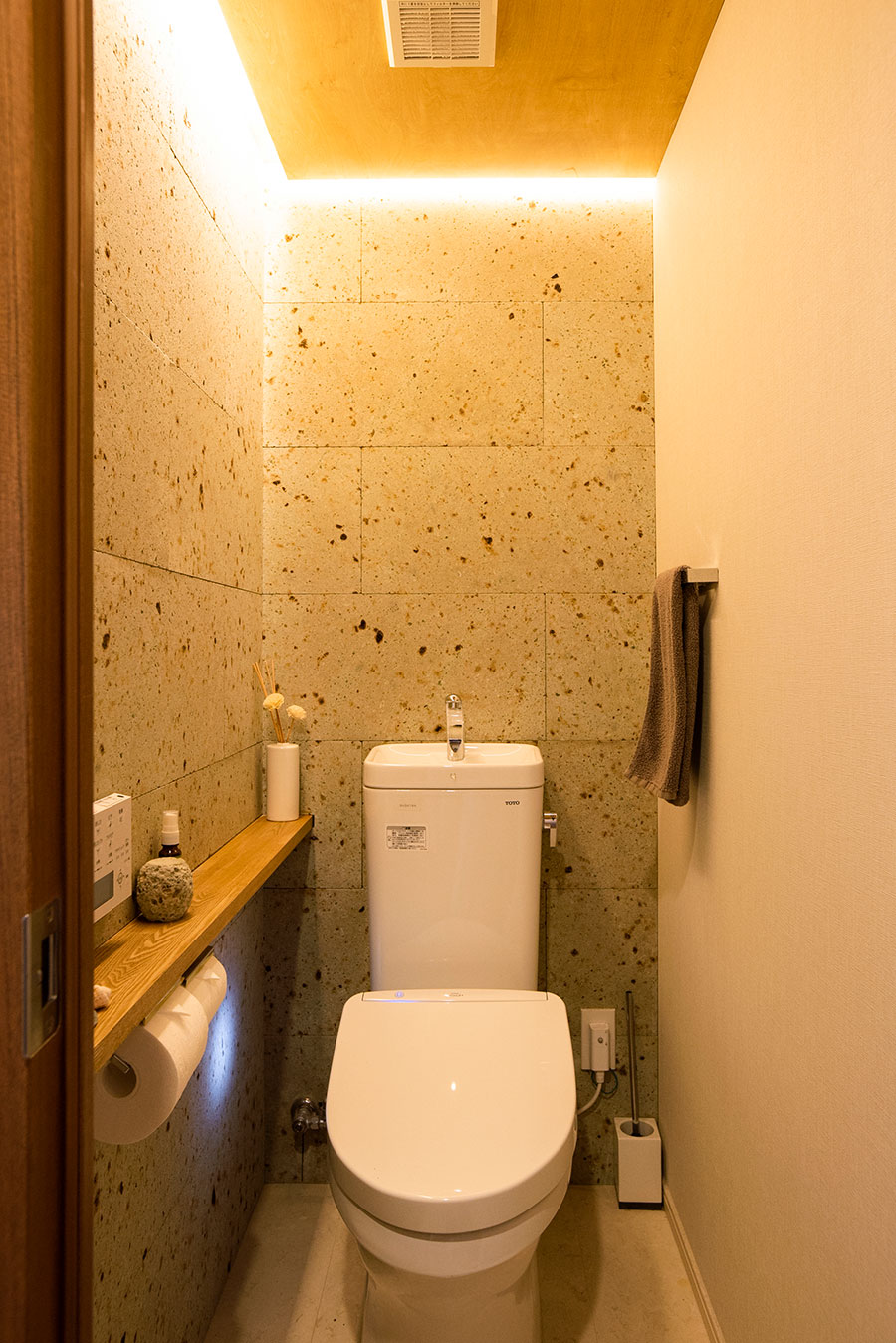 トイレにも大谷石を贅沢に。天井に板を張り、灯りを間接的に照らしている。