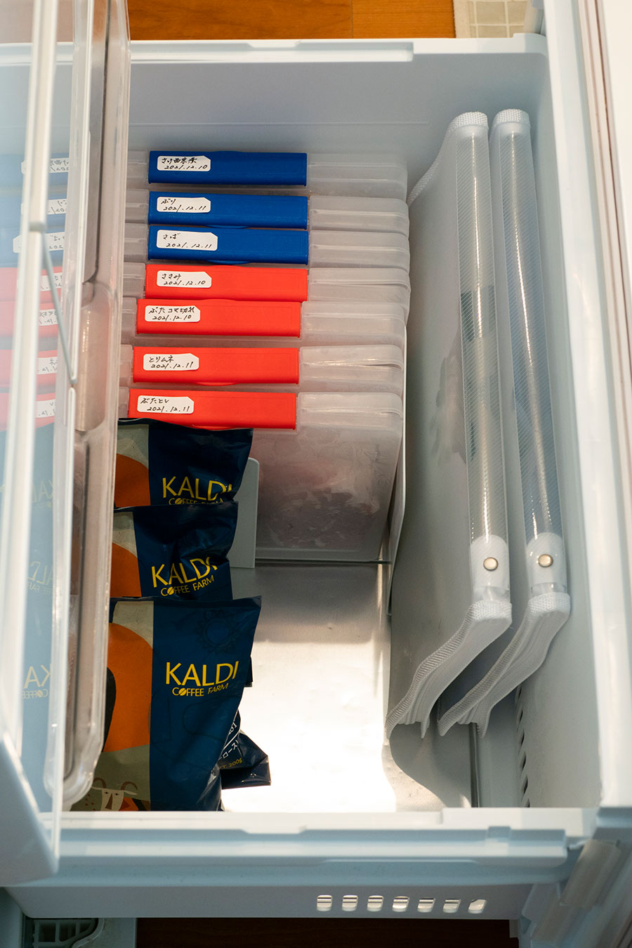 本棚のような冷凍庫。赤のファイルには肉類を、青のファイルには魚類を、小分けして保存。アイスノンもファイルケースに入れている。