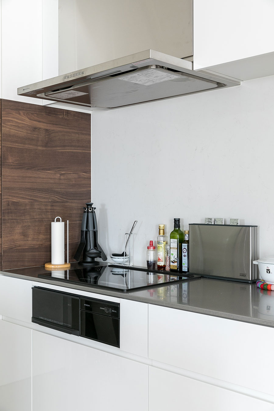 壁付キッチンにIHコンロを設置し、天板は熱に強いステンレスを採用。壁材はシーザーストーン。