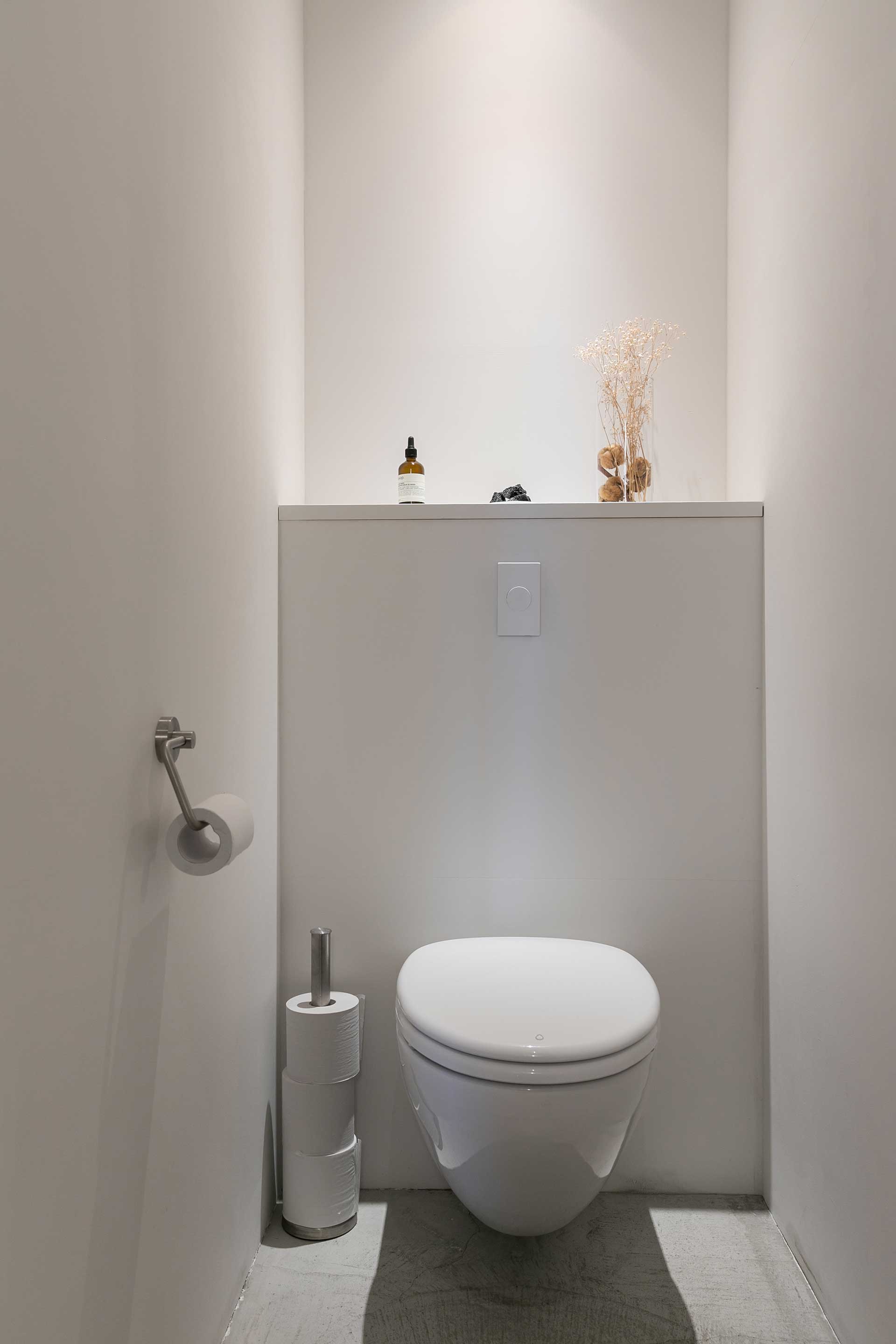 壁付けのLIXILのトイレは床から浮いているデザイン。「もともと公共のトイレのために作られたもので、掃除のしやすさは抜群です」。操作スイッチもシンプルでスタイリッシュ。
