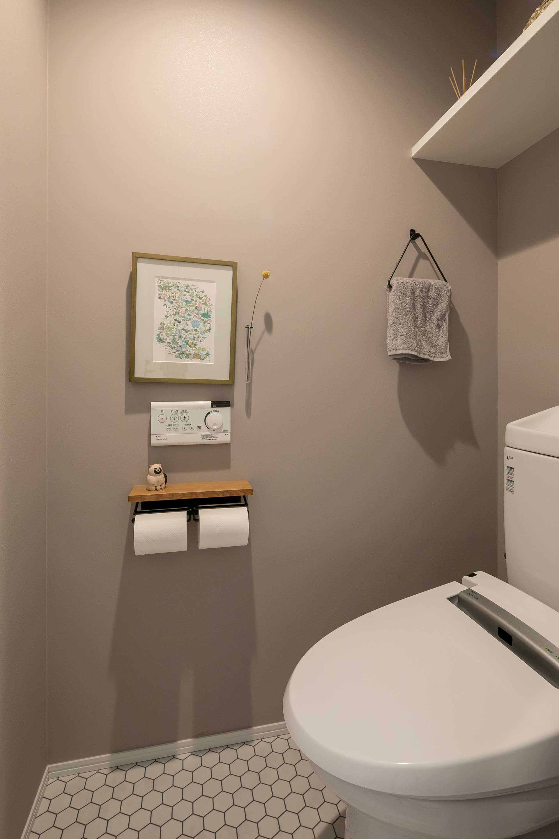 ビビッドな廊下やワークスペースとは対照的に水回りはグレーを基調としたシックな雰囲気に。トイレのタオル掛けにはアイアンを採用。床はタイル柄のクッションフロアにし、モダンな印象のある空間となった。