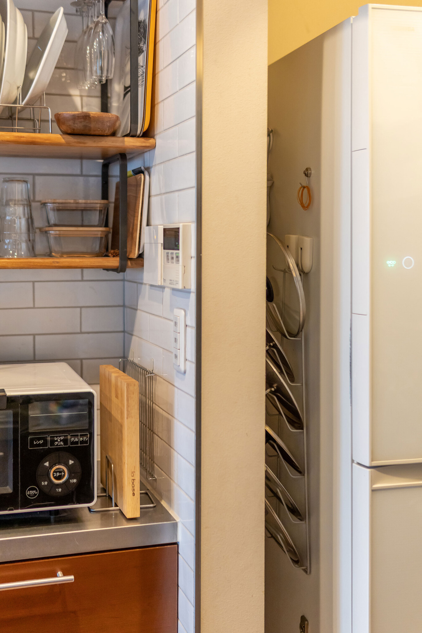 冷蔵庫と壁の隙間に鍋蓋を。コンロからも近く、立ったままでアクセスできる。