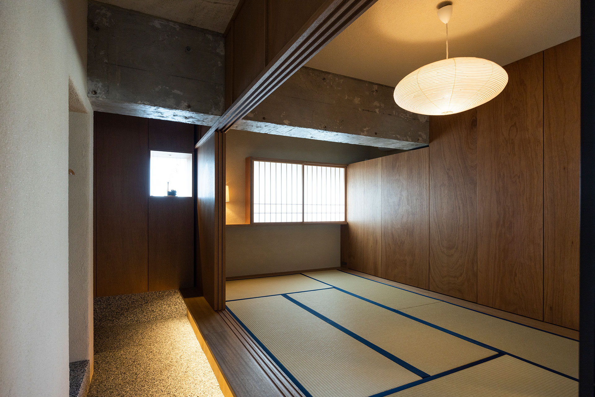 多目的に使える和室。オリジナルサイズの畳は匂いのしない和紙を使用したもの。畳の下と、ラワンのプッシュオープン式扉で覆われた壁面も収納になっている。縁側下の間接照明が幻想的。