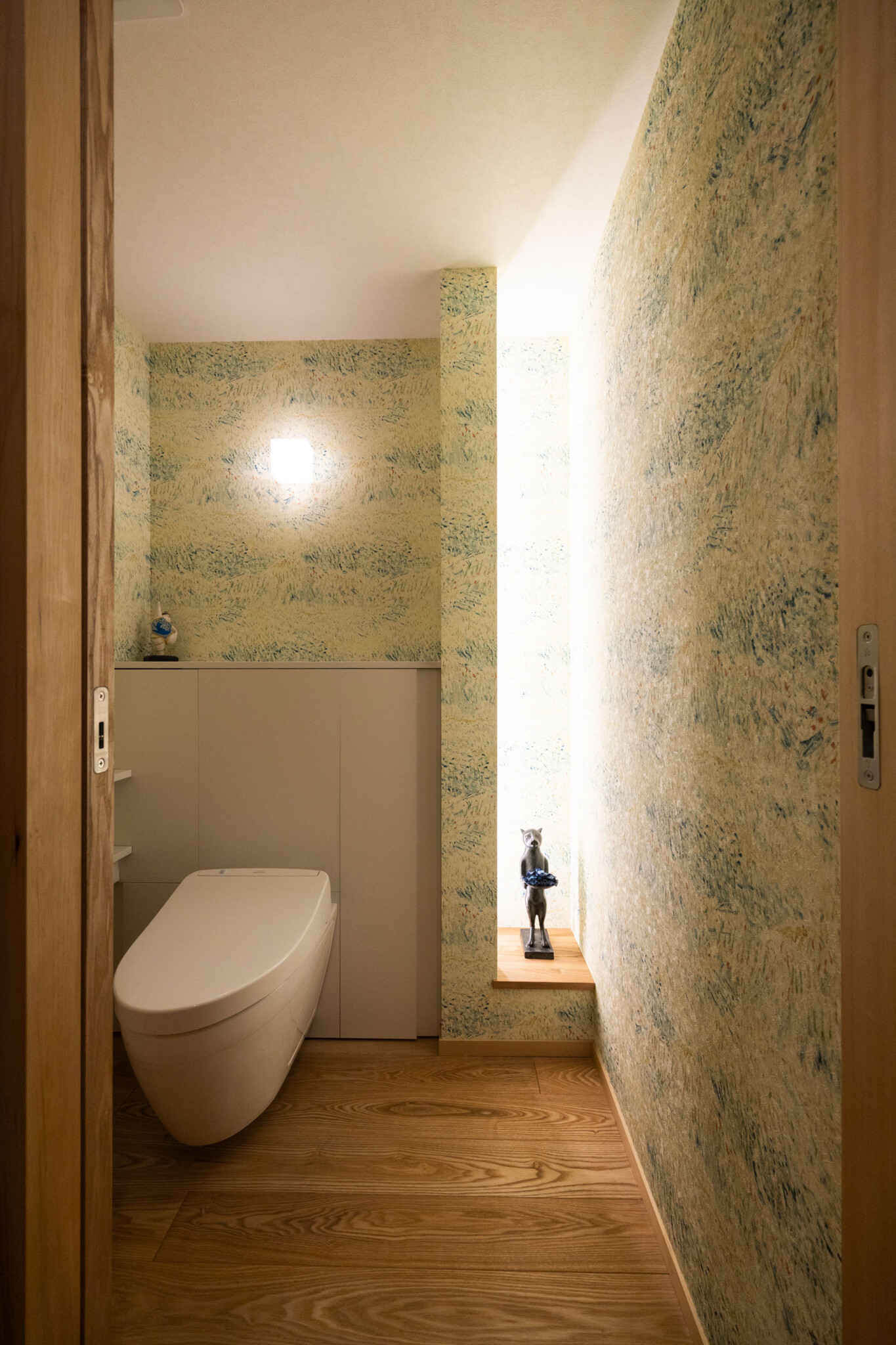 ドアを開けると雰囲気が切り替わるトイレ。ゴッホの絵をモチーフとしたオランダの壁紙をセレクト。トイレは掃除が楽なフロートタイプに。