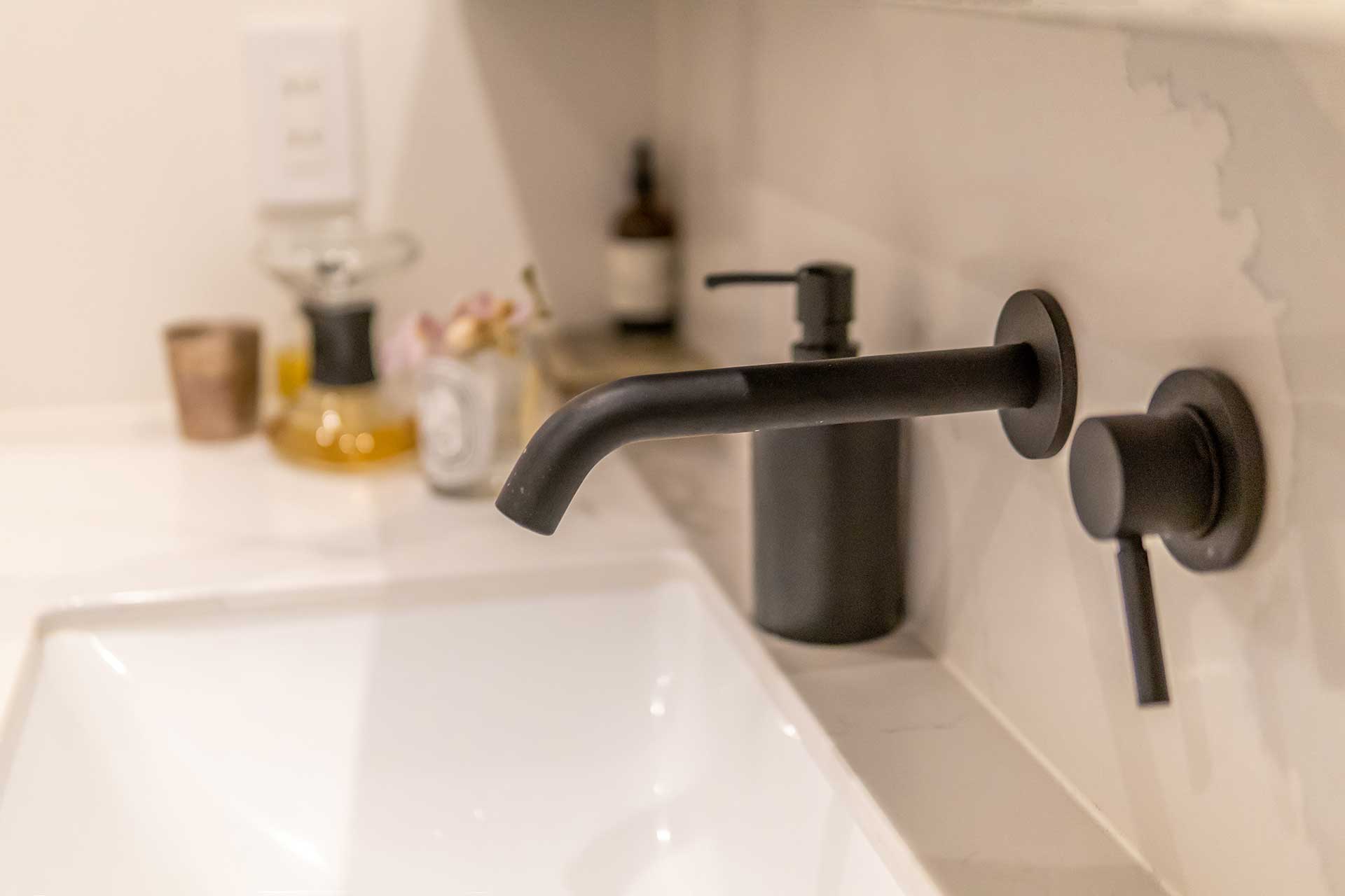 洗面にもキッチンと同じサイルストーンを使用。壁付けの水栓もアクセントに。