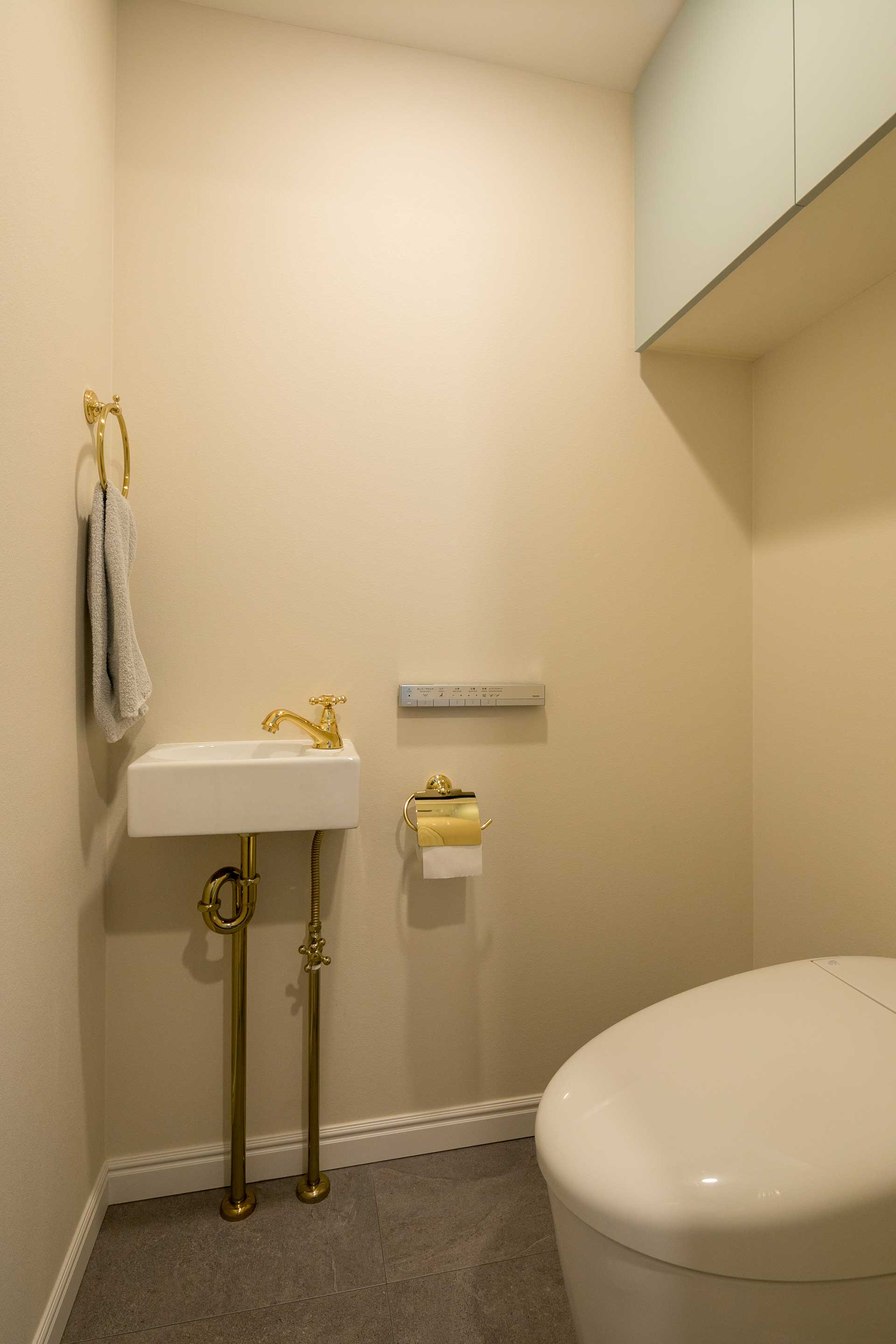 トイレは水栓やタオル掛け、給水・排水管をゴールドで揃えている。