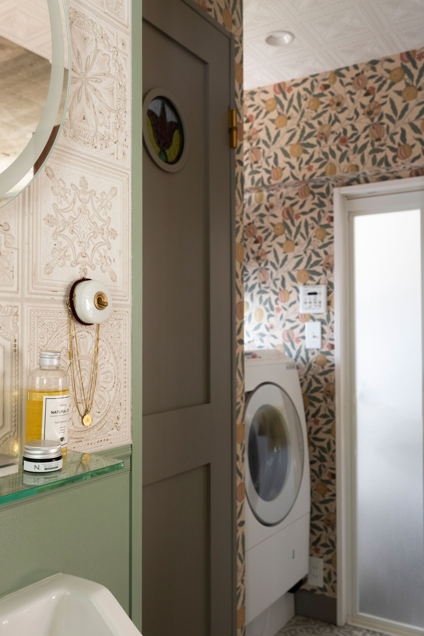 洗面台にはキッチンと同じタイルを、バスルーム前にはウィリアム・モリスの壁紙・フルーツを用いた。