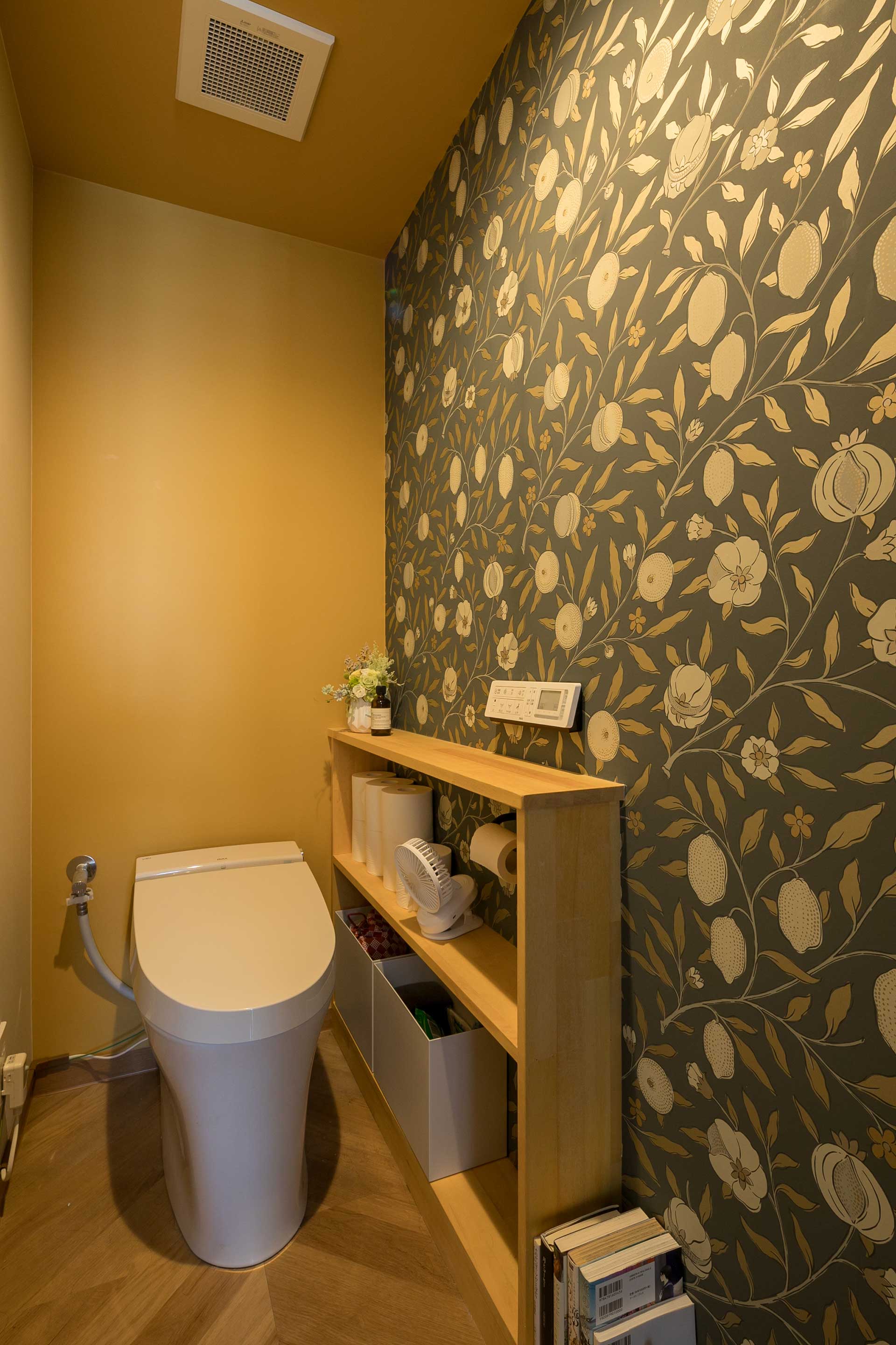 全体の落ち着いたトーンとは対象的に、明るいトーンを基調にアクセントとしてウィリアムモリスの壁紙を採用したトイレ。