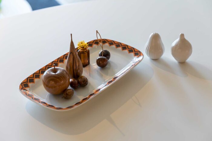 繊細な木の工芸品をドイツのヴィンテージのお皿に集めてディスプレイ。ソルト＆ペッパーはジョナサン・アドラー。