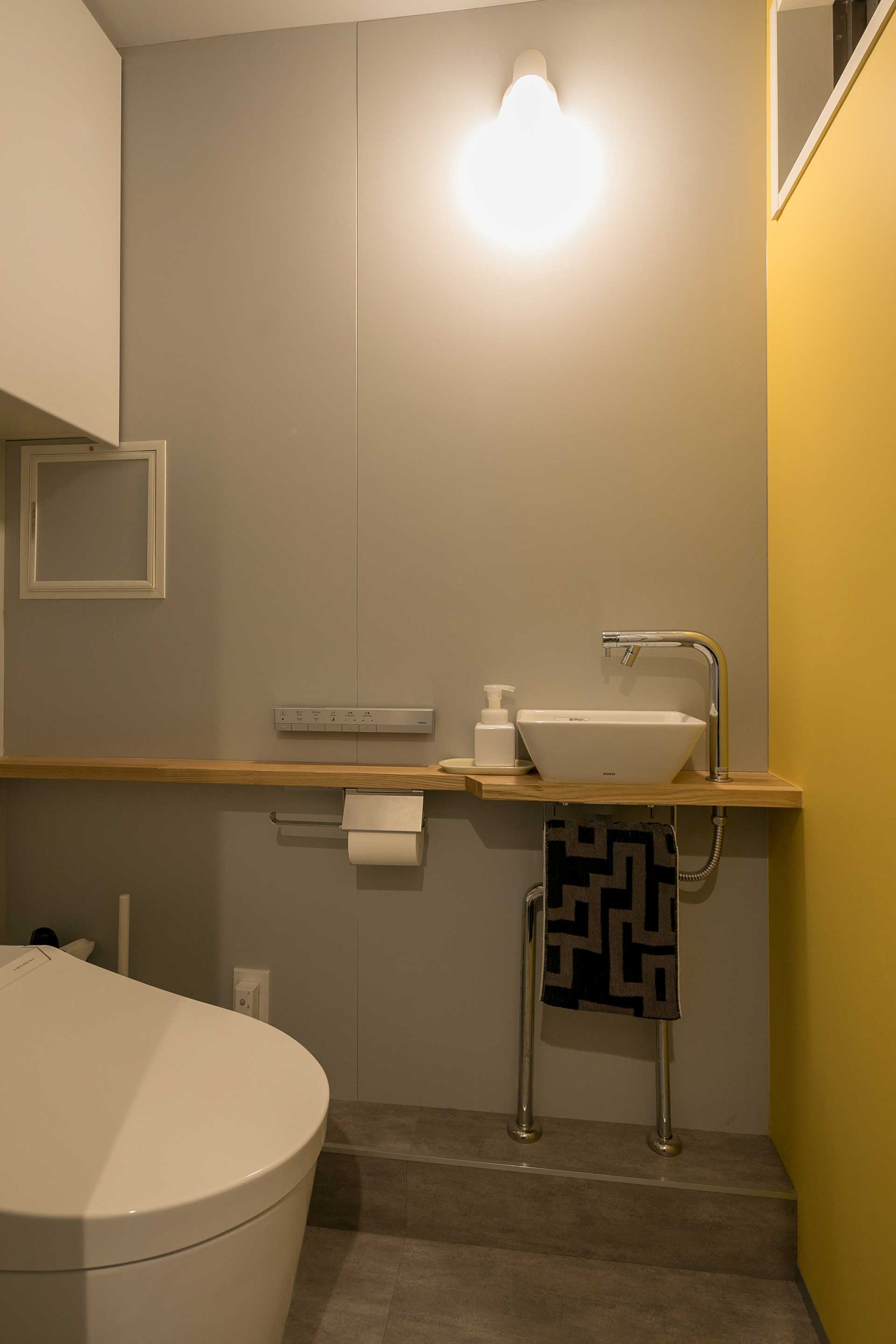 トイレには夫の希望で黄色のクロスを使用。全体的にモノトーンの統一感をもたせつつ、個室となる空間に遊び心を見せる。