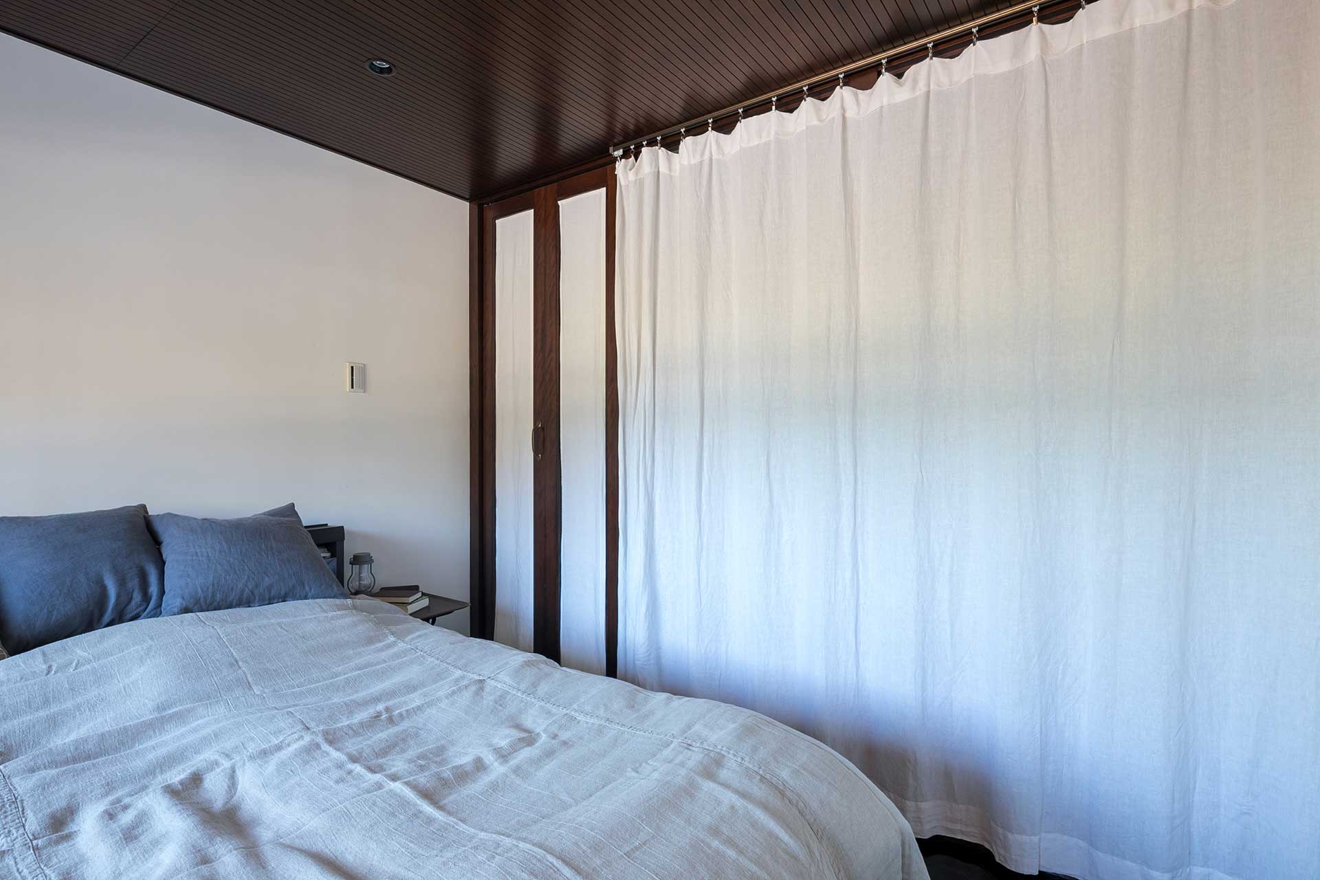 寝室と玄関の間のカーテンは、昼間は開けて夜は閉めるそう。カーテンをひくと一気に雰囲気が変わり、こもり感のある空間に。