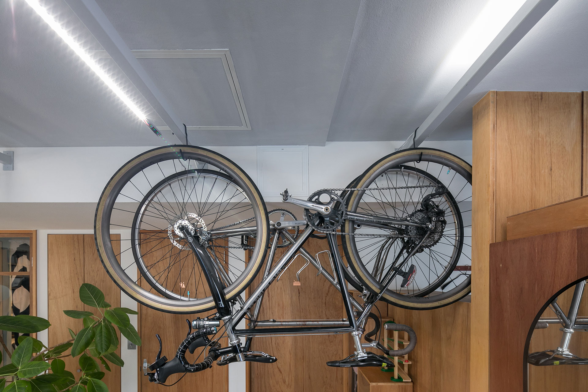 自転車をかけるハンギングバーには、動かせるバーライトをのせている。作業時には左側のようにバーライトを垂らして光量を確保できる。