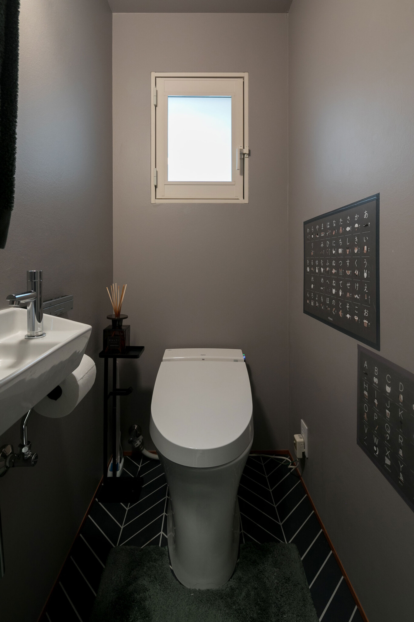 トイレの壁は落ち着いたグレーと、白の目地で張った黒のタイルに。