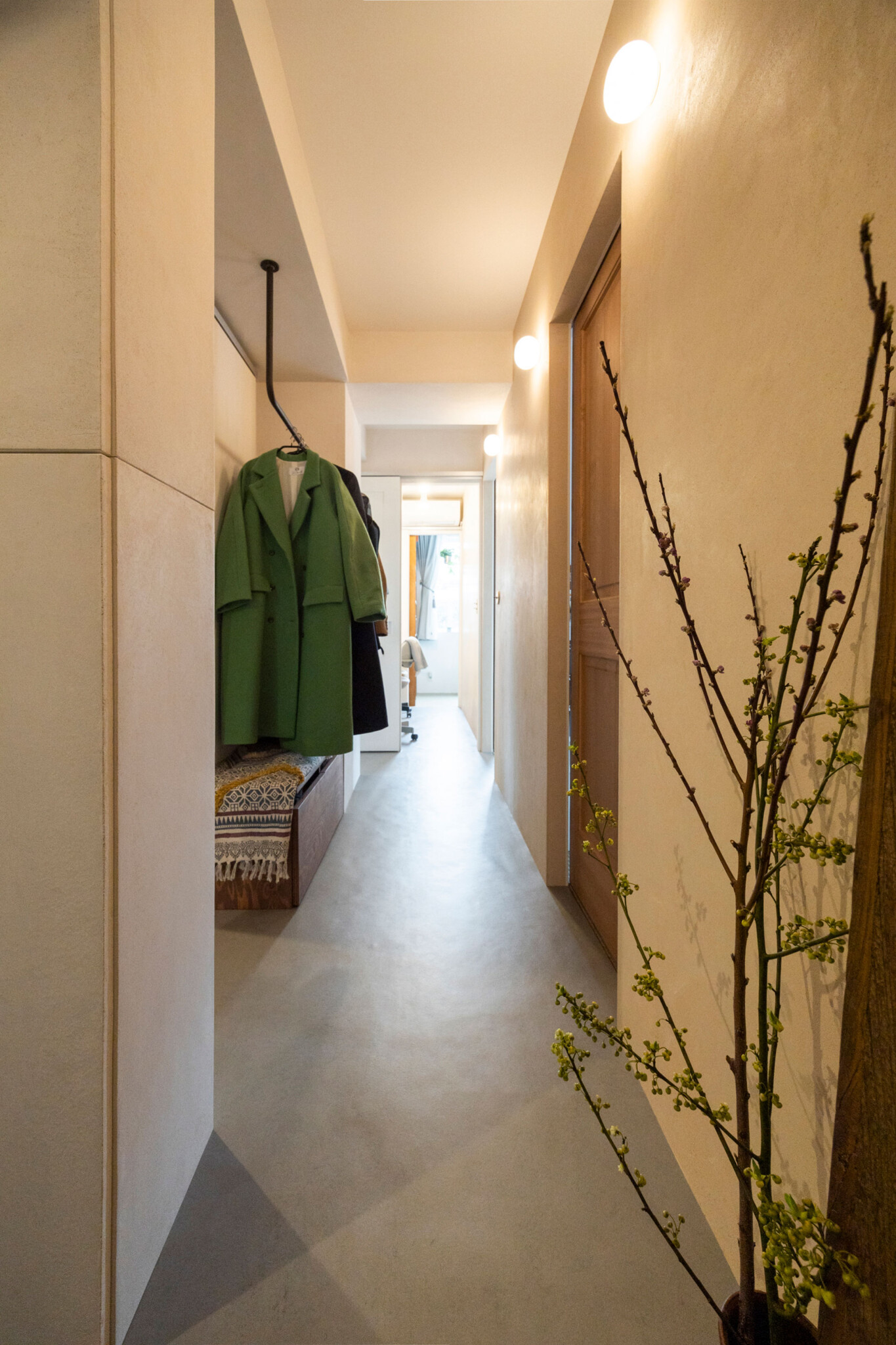 オープンなクローゼットとして、コートハンガーを設けたサブ廊下。突き当たりは主寝室。左右の壁で色を変えている。