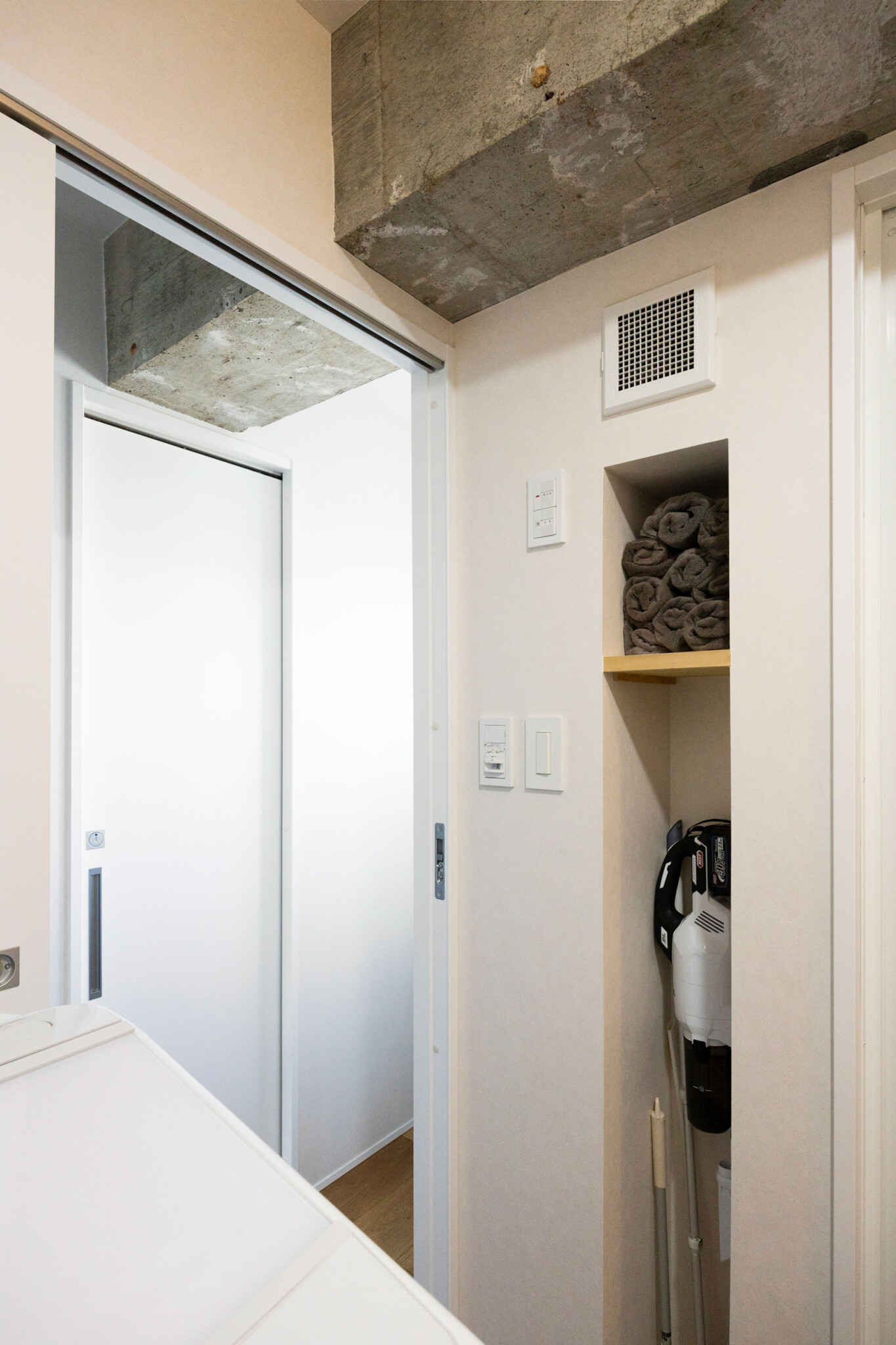 浴室横の壁もニッチを設け、タオルや掃除機の収納スペースを確保。「ルンバが来れない場所をササッと掃除するために使ってます」