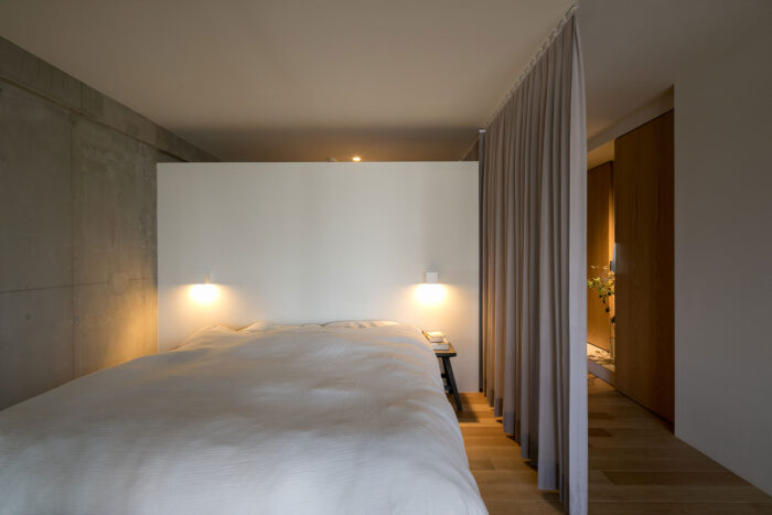 寝室の奥はウォークインクロゼット。空間の広がりの演出と換気のため壁の上部を開けている。