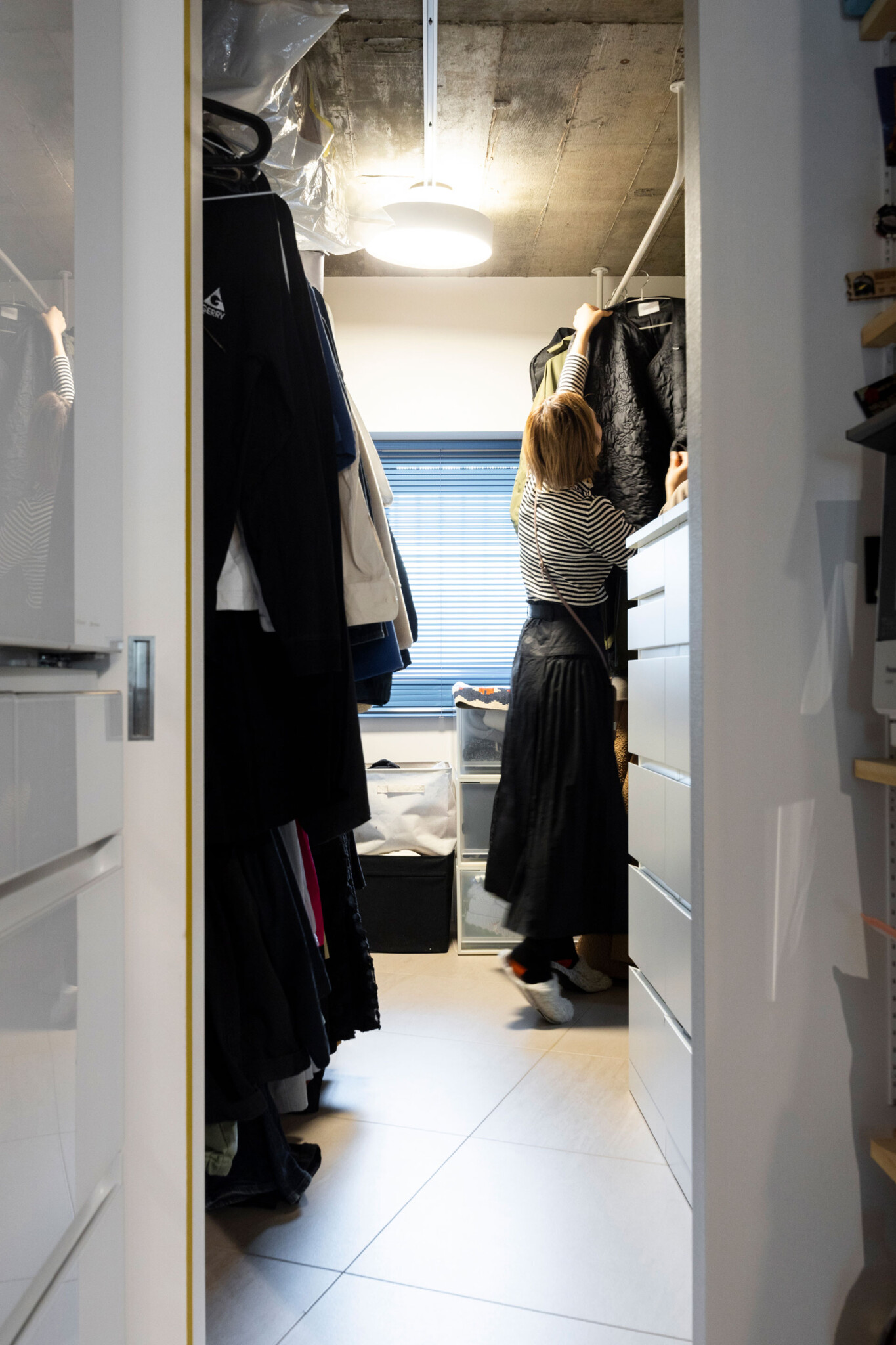 洋服はハンガーにかけて収納し、畳まないことで家事の時短を図る。ウォークインクローゼットは、キッチンから玄関へとグルリと回遊できる。