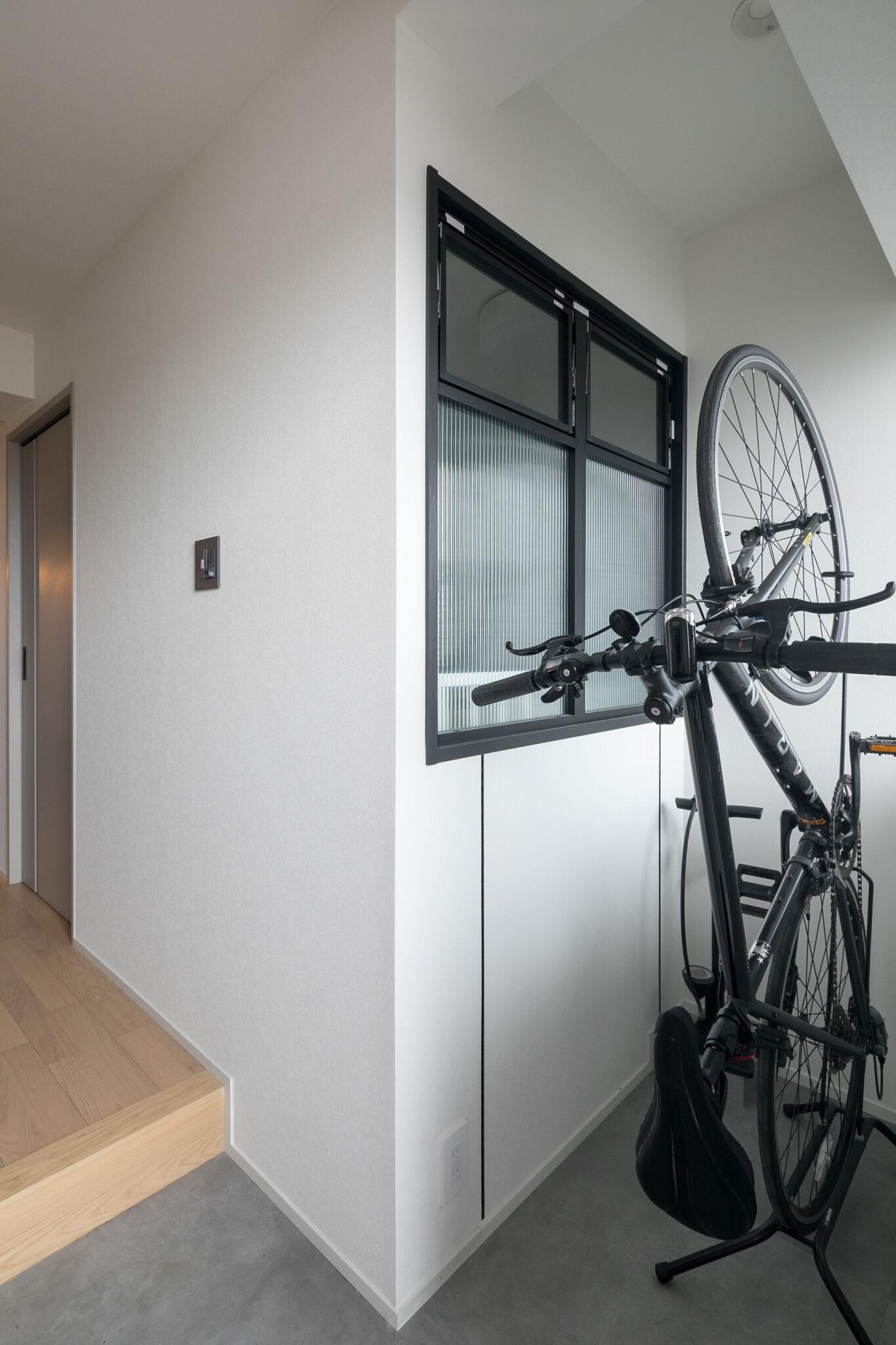 寝室の一部だったスペースを自転車やベビーカーを置く土間にした。「使いづらいスペースだったので切り離して土間にして、寝室との間に室内窓をつけました」と夫。玄関に視覚的な広がりを持たせる効果もある。