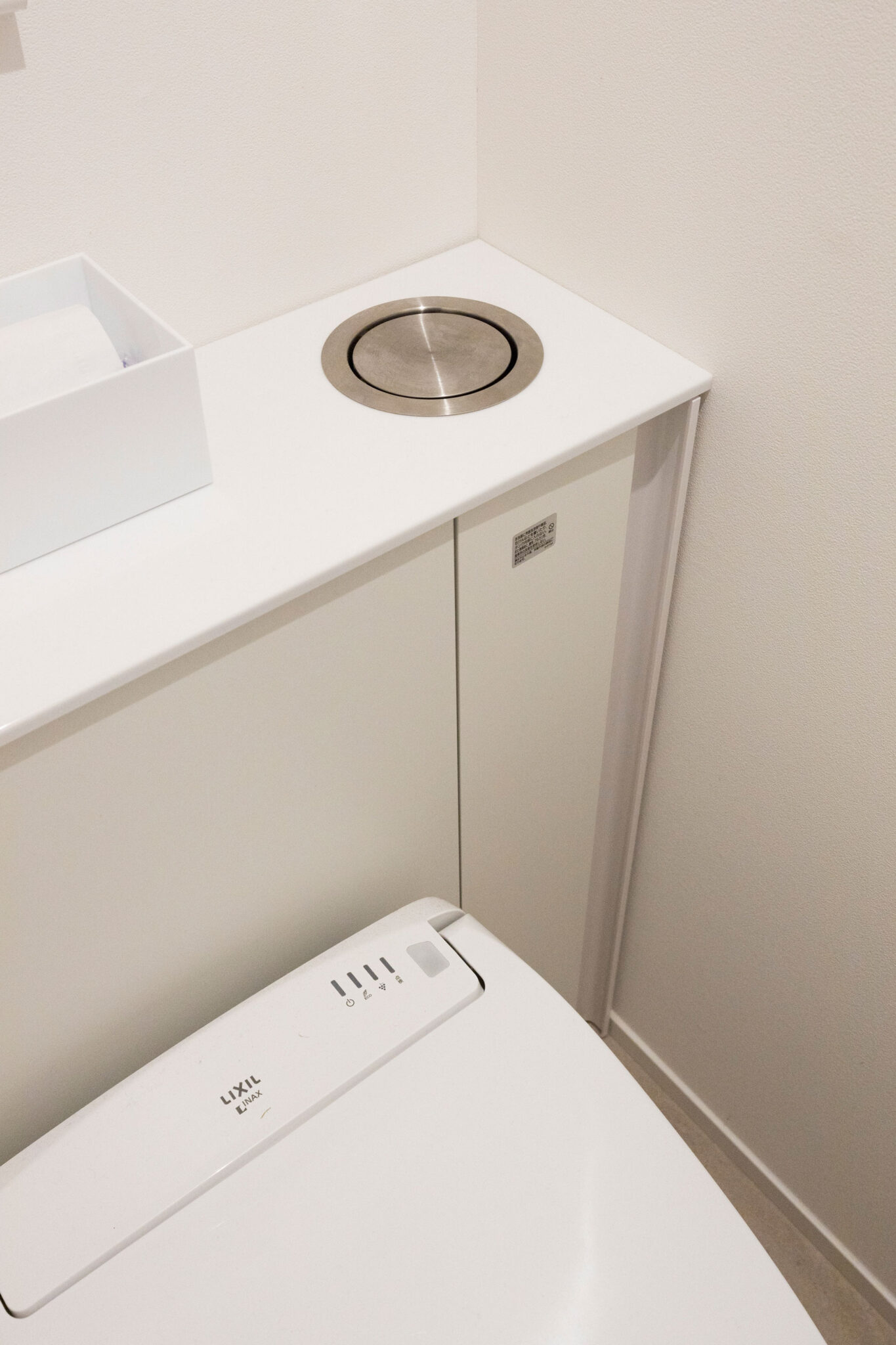 トイレは、タンク部分がキャビネットに隠れ、タンクレスのように見せられるLIXILのリフォレを採用。一部に穴を開けて、中に置いたゴミ箱にゴミを投入できるようにした。
