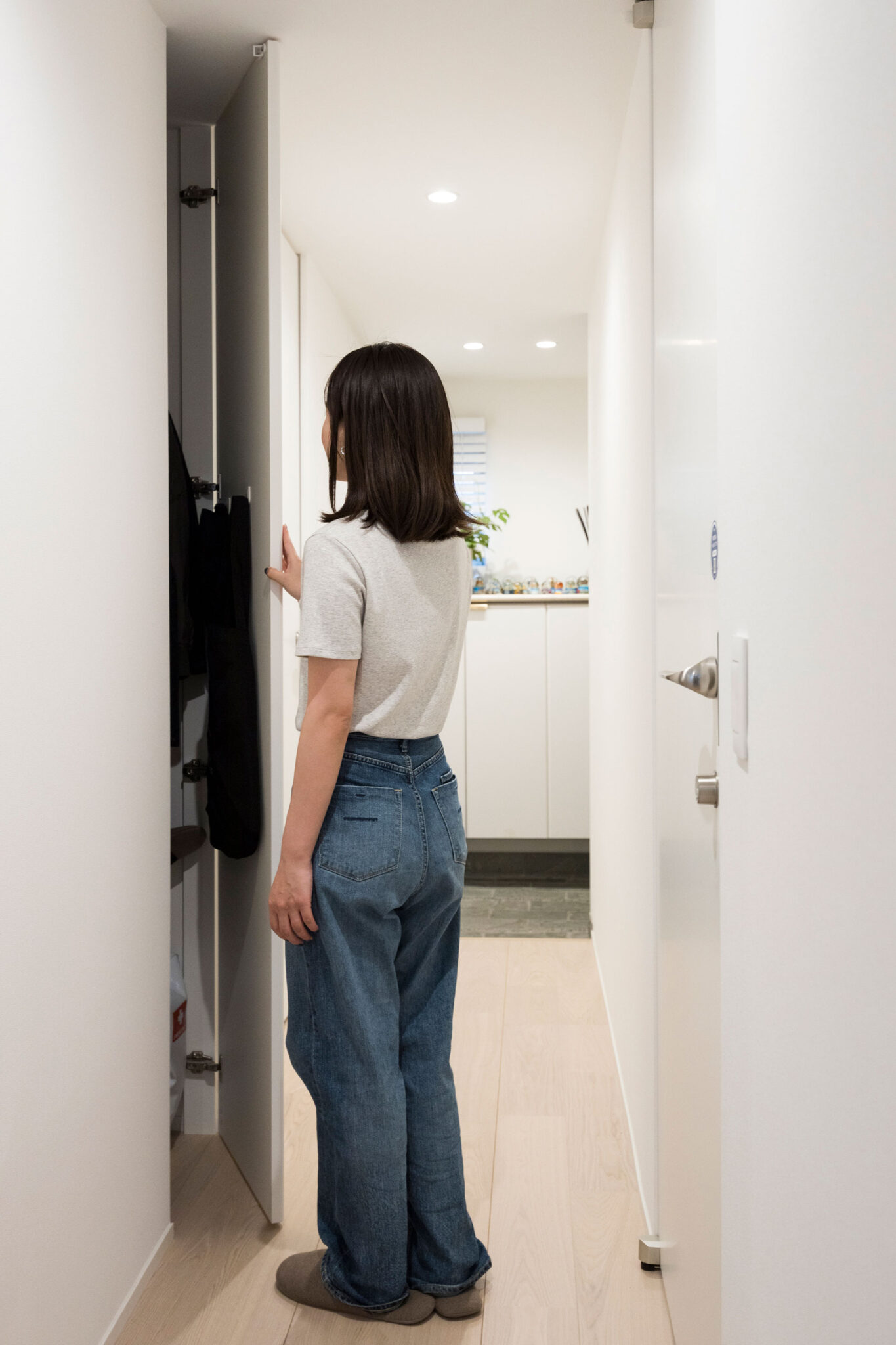 アウターをかけられる収納を玄関脇の廊下に。すべてフルハイトのドアにこだわっている。電動自転車のバッテリーもここに。