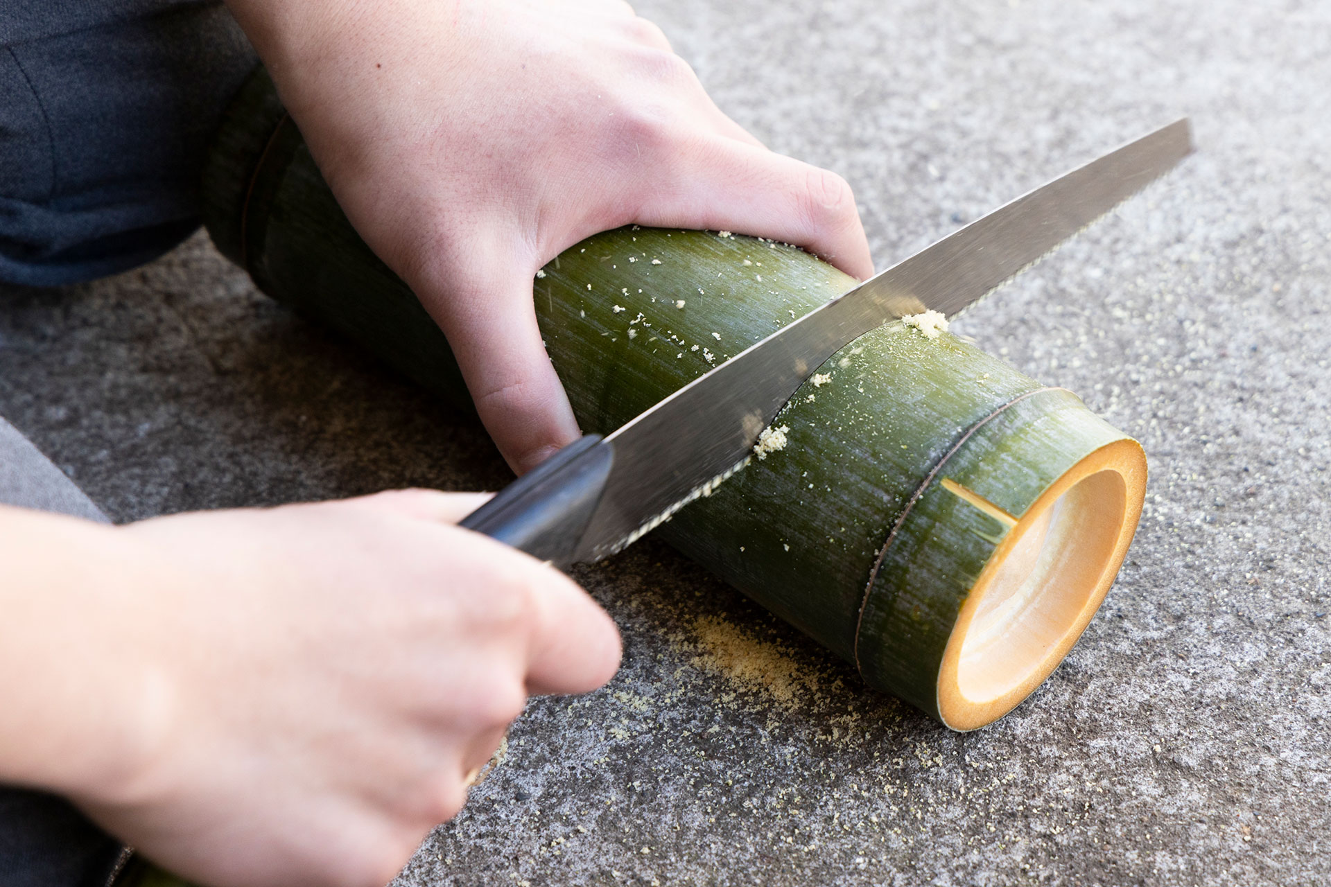 青竹に蓋を作る。ノコギリで2箇所に切れ目を入れる。
