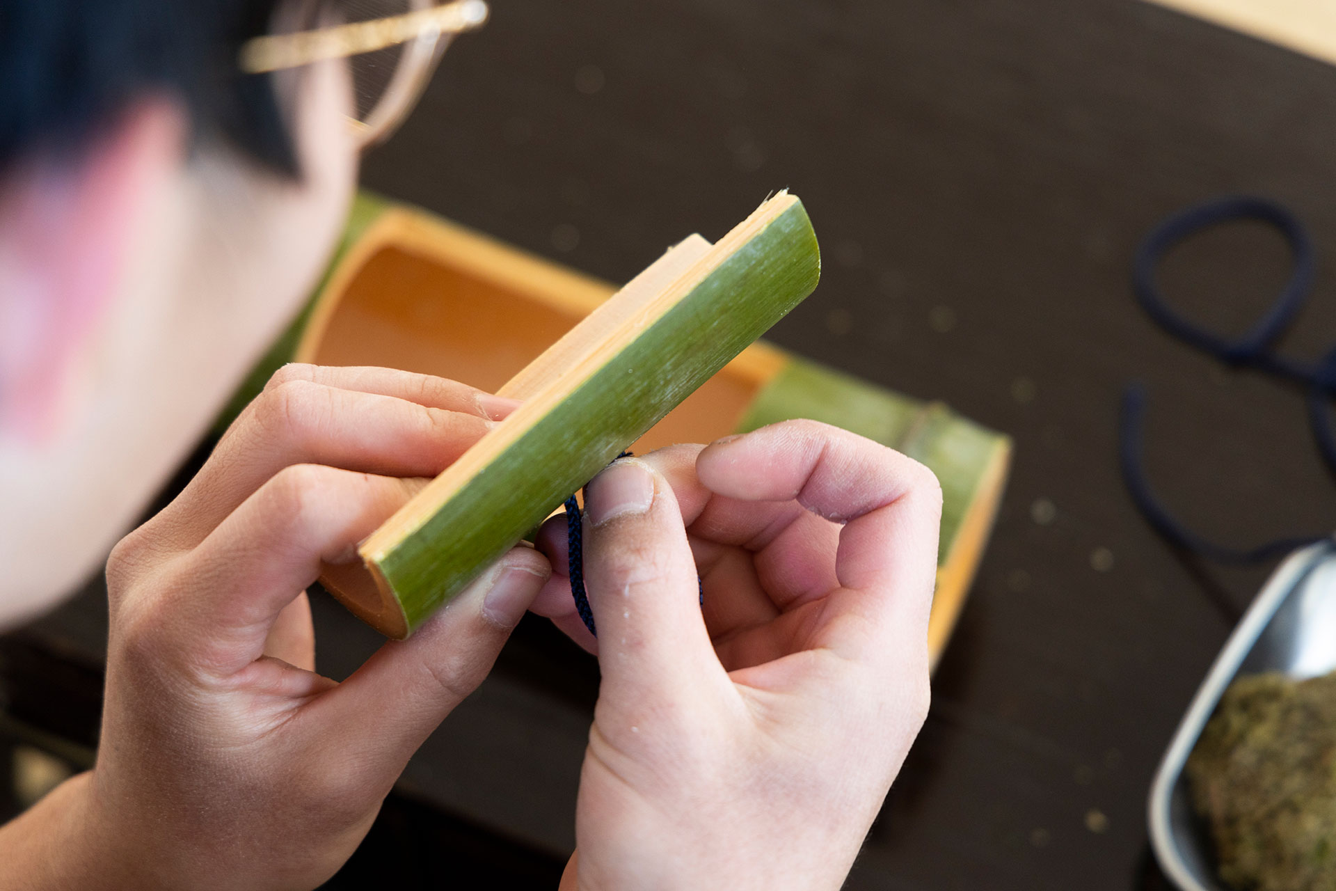 穴にヒモを通し、つまみを作る。