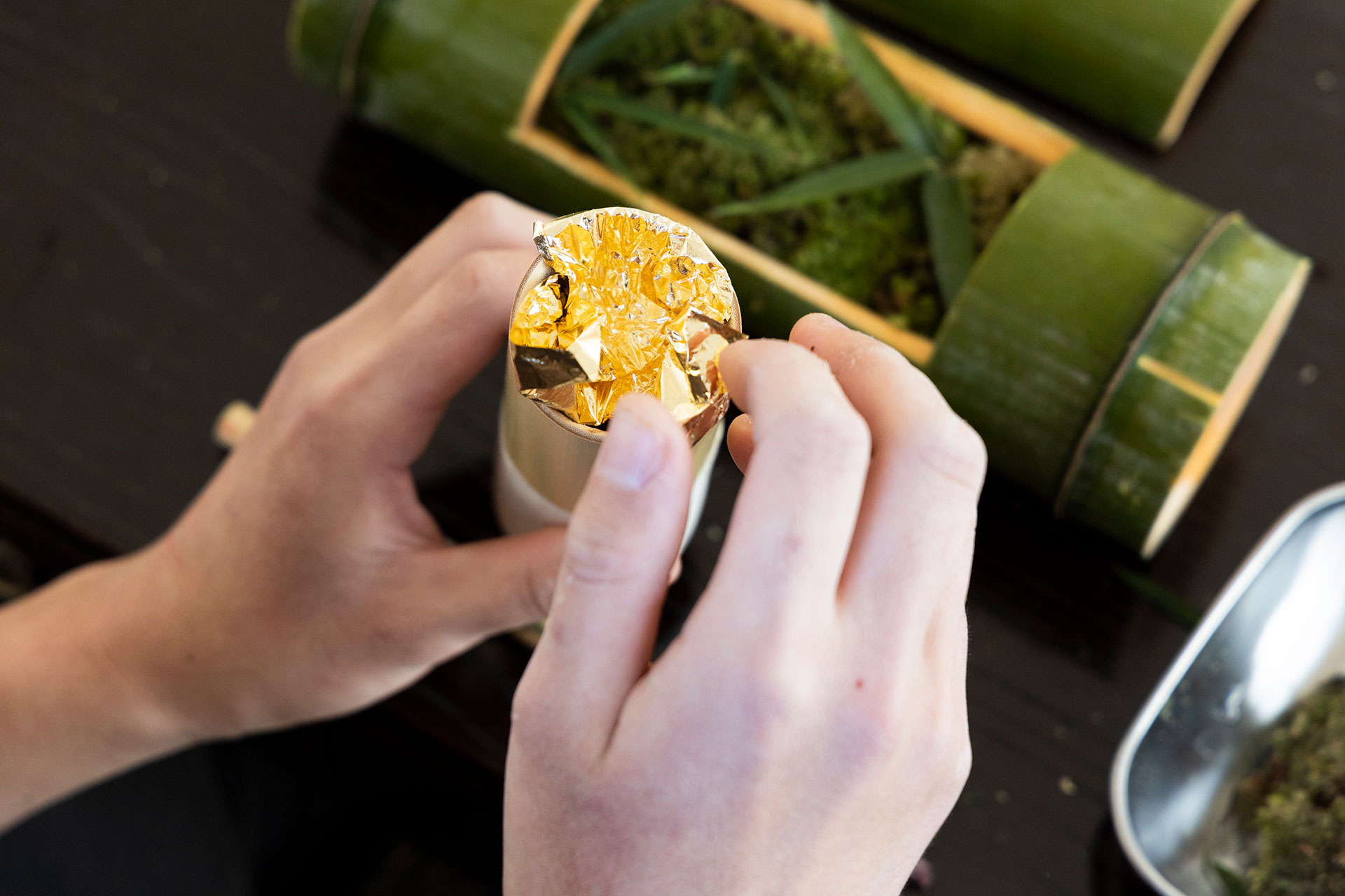 砂子筒に金箔を入れる。砂子筒は日本の伝統技法、砂子表現を行う際に使う竹製の筒。