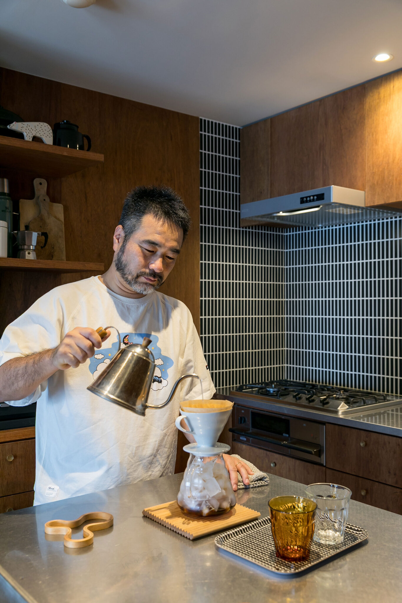キッチンのタイルは、黒のタイルに白の目地を合わせてコントラストを楽しむ。おいしいアイスコーヒーを振る舞っていただいた。