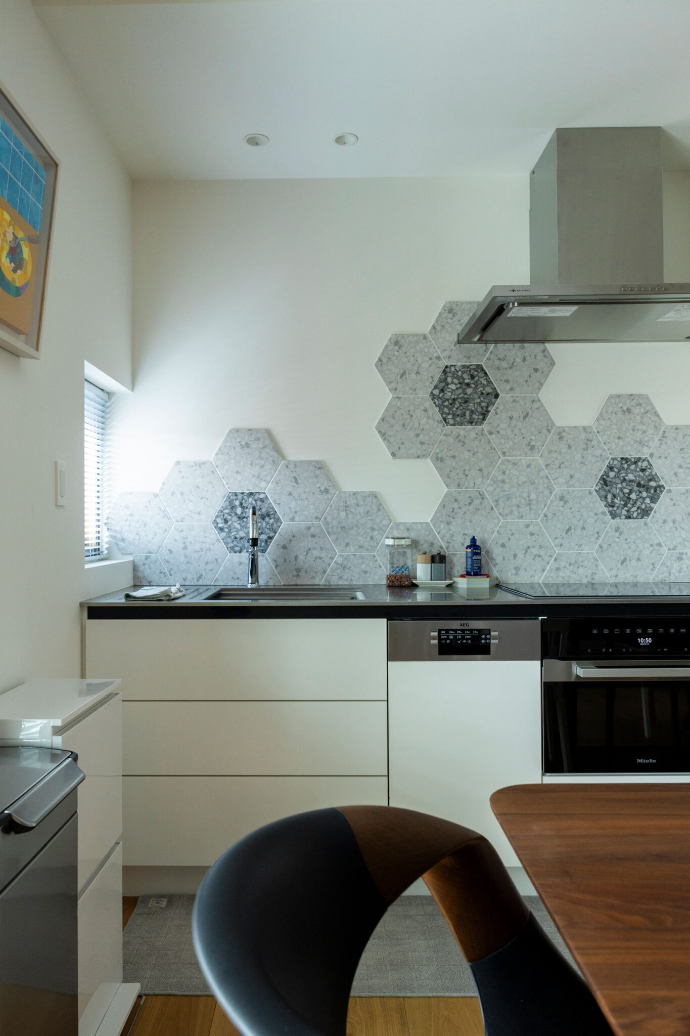 キッチンはシンク内の使いやすさにもこだわった。名古屋モザイクのハニカムタイルを使って、花をモチーフに壁面をアレンジ。