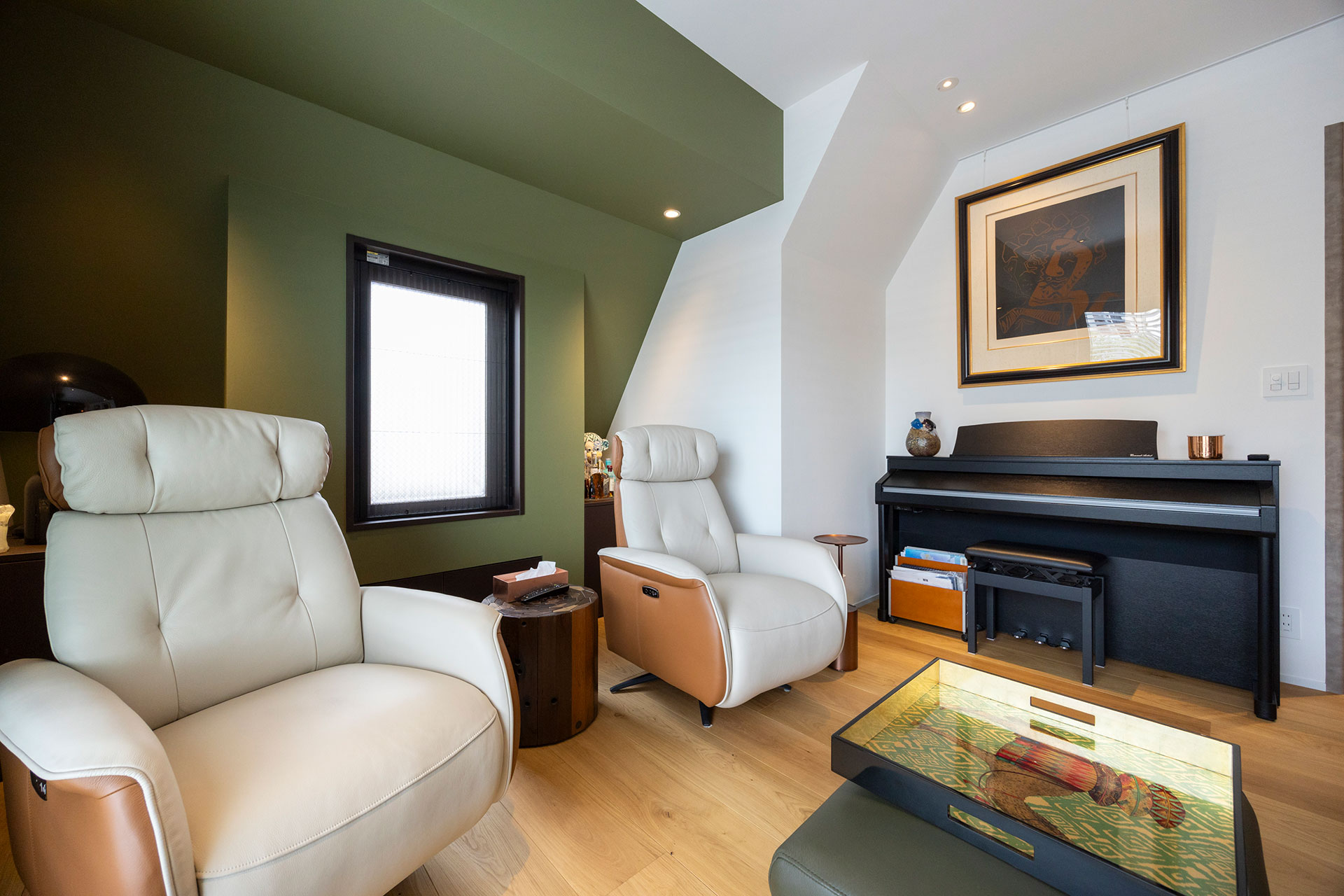 デッドスペースになっていた出窓の周りを取り壊し、開放的に造りかえた。上質な革を使ったCORIUMのアームチェアはフルフラットになり、最高の座り心地。ピアノの上にはピカソのリトグラフを飾る。