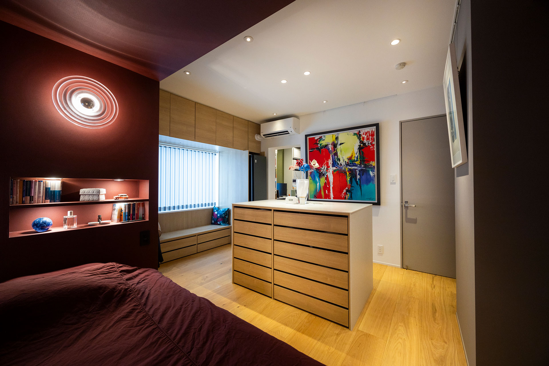 中央のアイランド収納を挟んで回遊できる造り。右手の扉奥にバスルーム&洗面がある。アイランド収納は両側に機能をもたせた。こちら側は引き出しに。