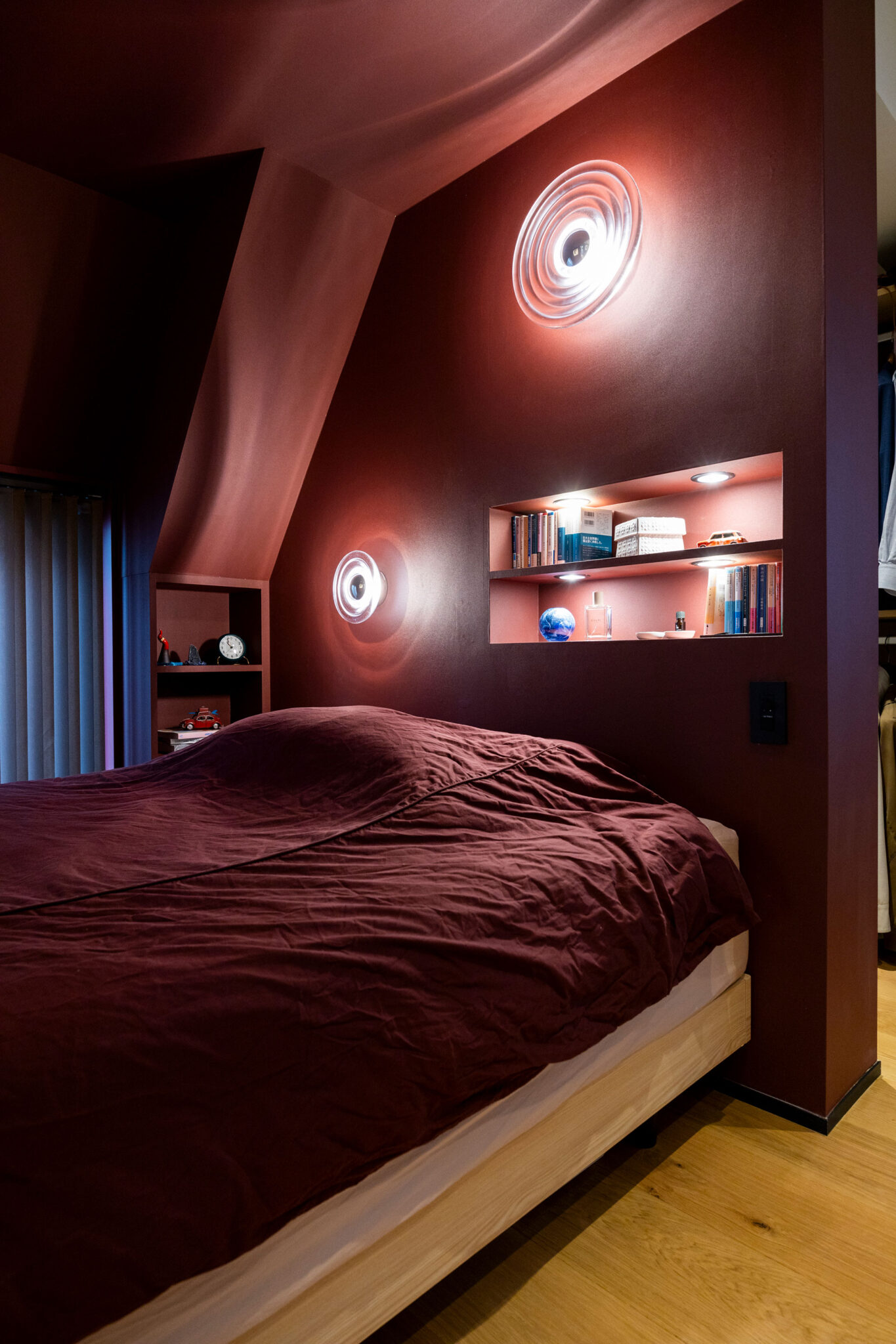 包み込まれる寝心地のベッドスペース。壁の照明はTom Dixon。