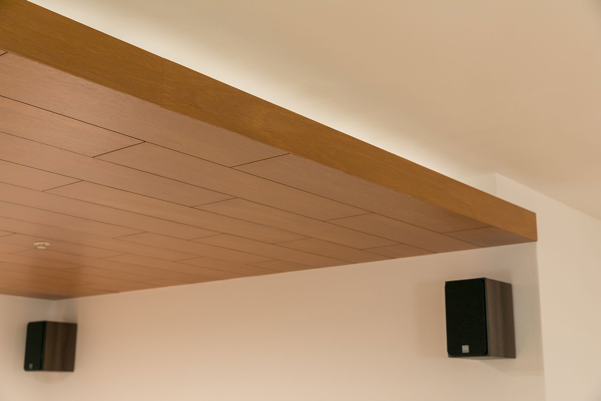 ゾーニングに一役買っている板張り天井。側面にも板を貼ることで、厚みのある板材を演出した。