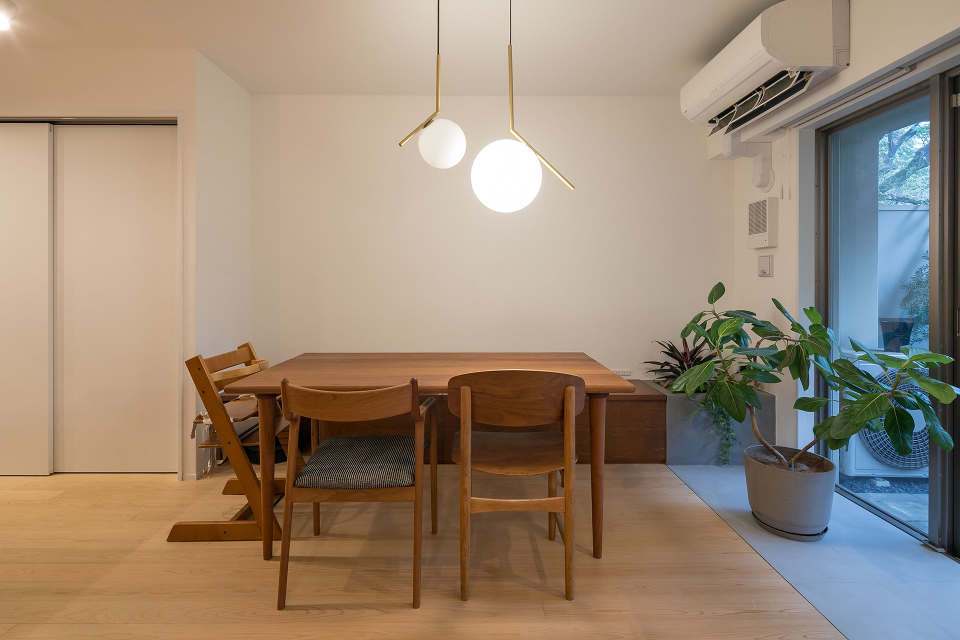 ダイニング側にもデザイナーズ家具が並ぶ。家具が馴染むよう造作ベンチや床などの素材や色にこだわった。