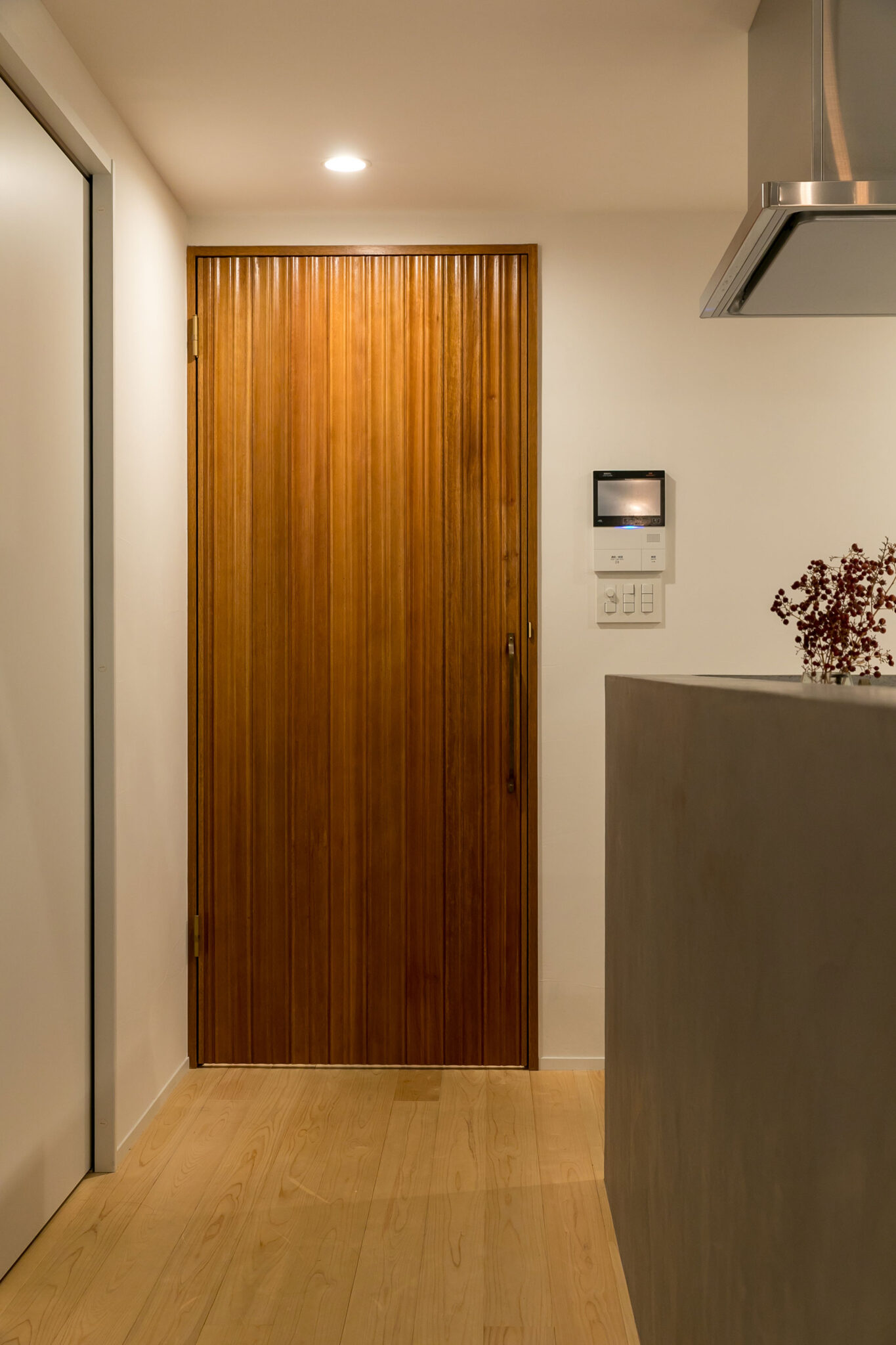 造作のリビングドアはベンチと同色のリブ材を使用。リブ材の縦の流れを活かすため、縦向きの取手を取り付けた。