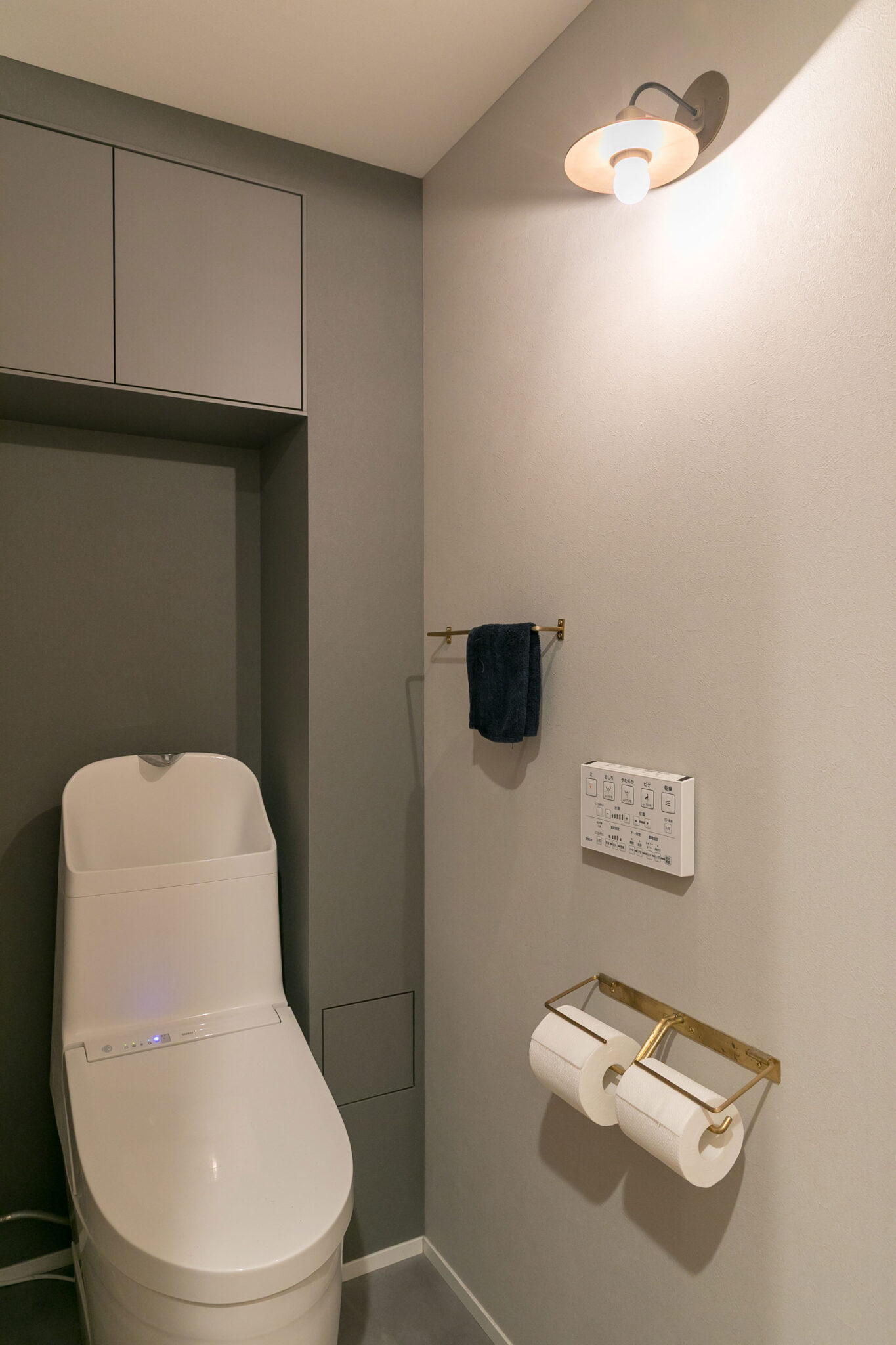 「明るすぎるより、少し暗い雰囲気を出したかったのでグレー系でまとめました」と妻。真鍮のブラケットライトやペーパーホルダーも「千sen」のアイテム。