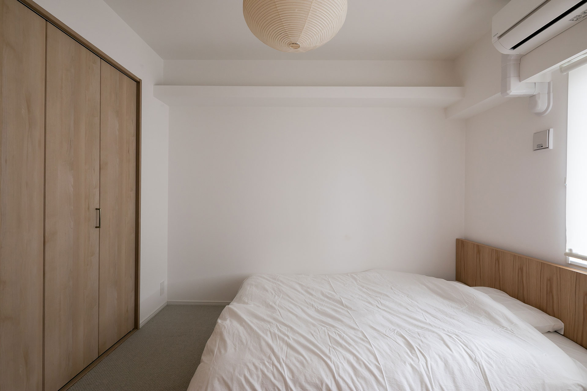 当初、自宅全面の床を絨毯することを望んでいた夫だったが、実用性を考えて寝室のみにした。照明はイサム・ノグチの「AKARI」。