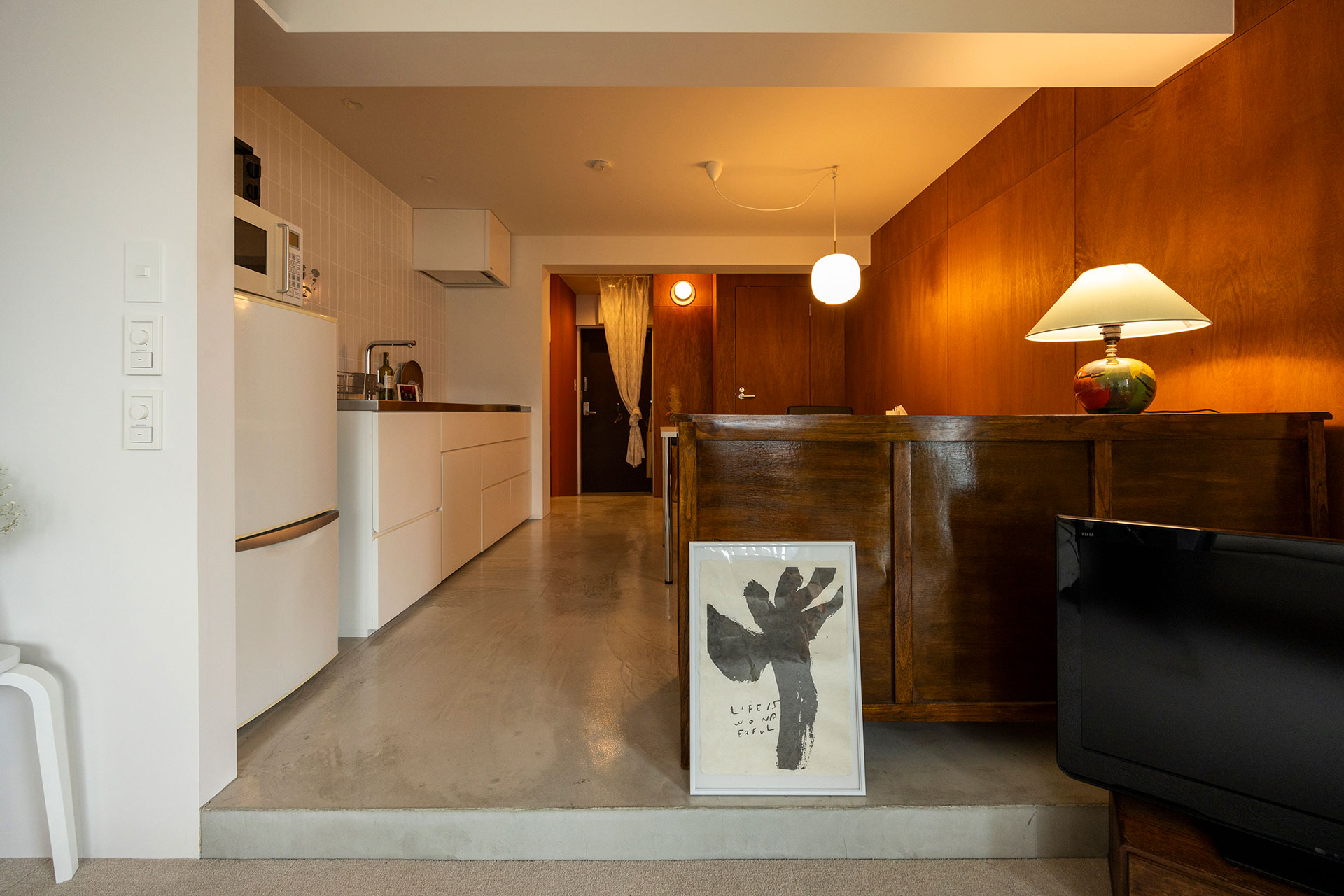 仕事場兼ダイニングキッチンの床は、配管の引き回しにより、リビングから1段上げた。低めの天高で包み込まれるような雰囲気に。