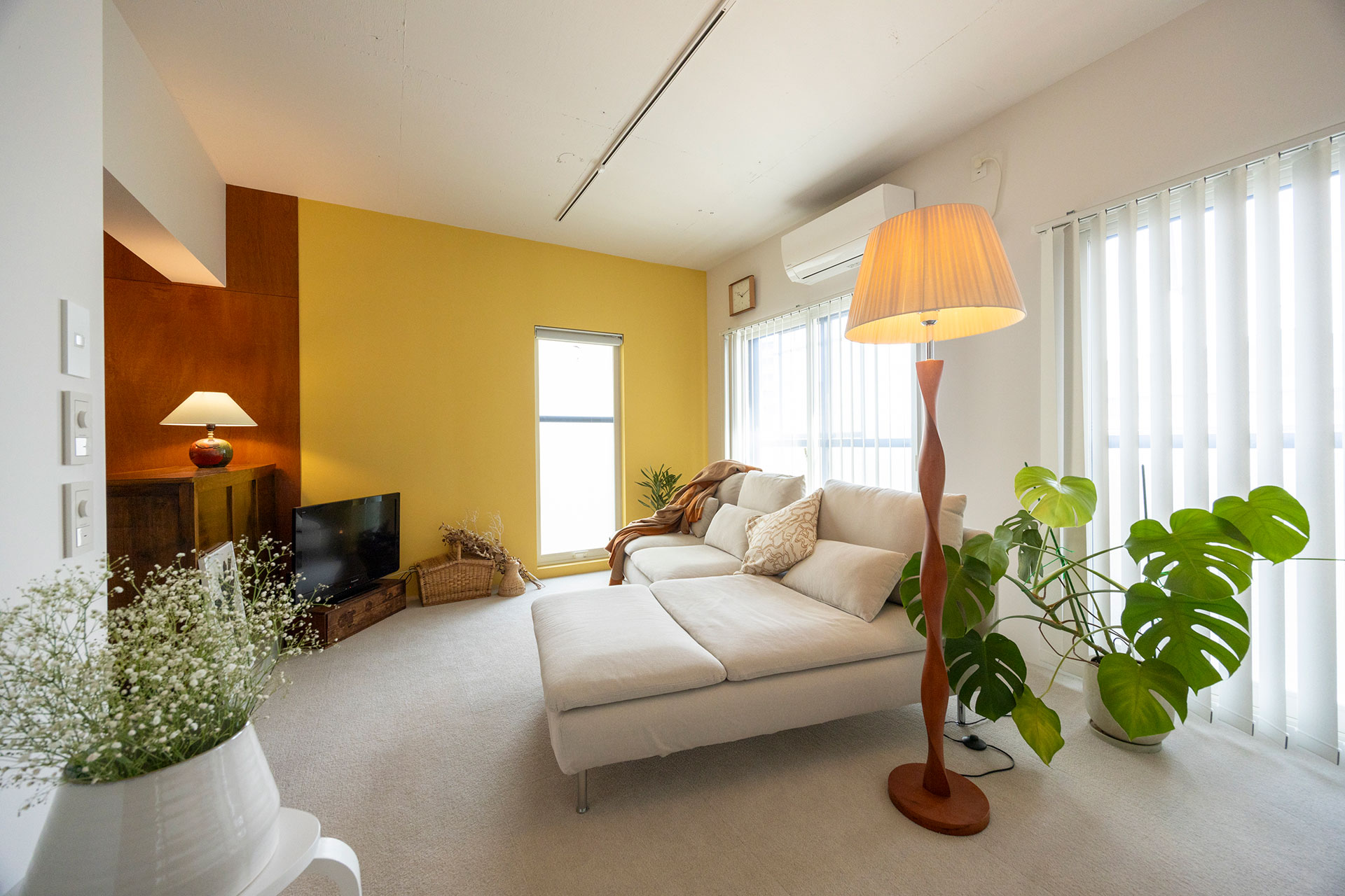 二人分のベッドとしても使えるIKEAの大きなソファを置いたリビング。全体にベージュのタイルカーペットを敷いた。汚れた箇所のみ取り替えられるのが便利。