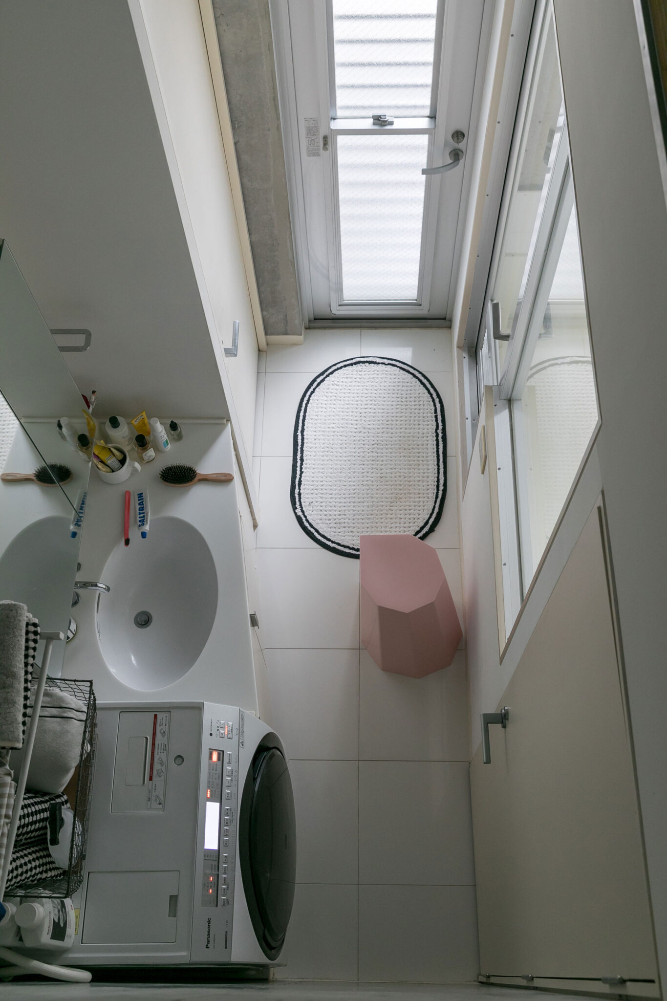 ３階から洗面やバスルームを見下ろす。ピンク色のスツールは、アウトドアでも使えるリサイクル可能なプラスチック製。「この『アーノルドサーカススツール』は、スタッキングができて、引っくり返すとカサ立てにもなります」