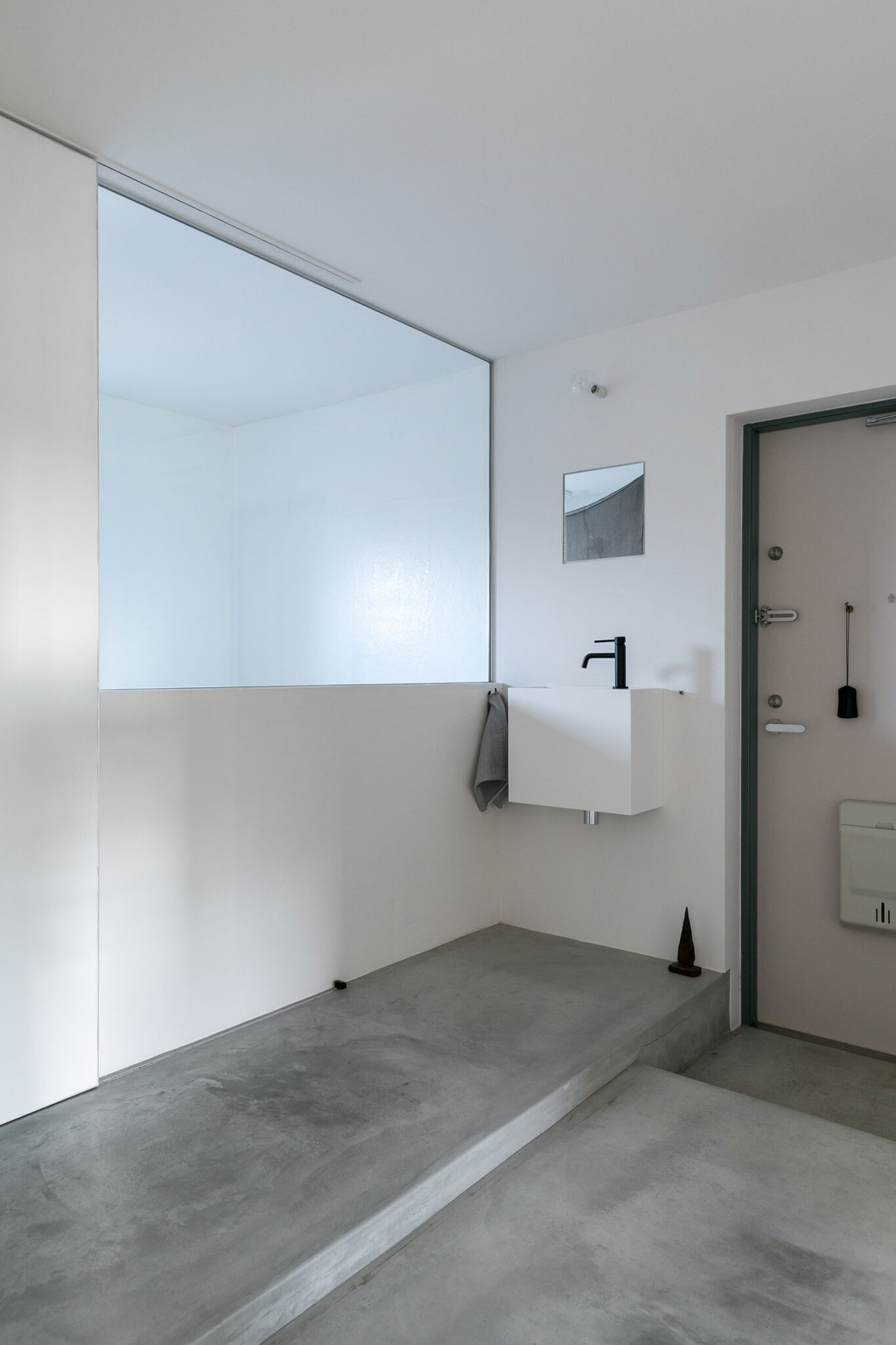 玄関入ってすぐに手洗いを設置。室内窓の向こうがバスルームになっている。